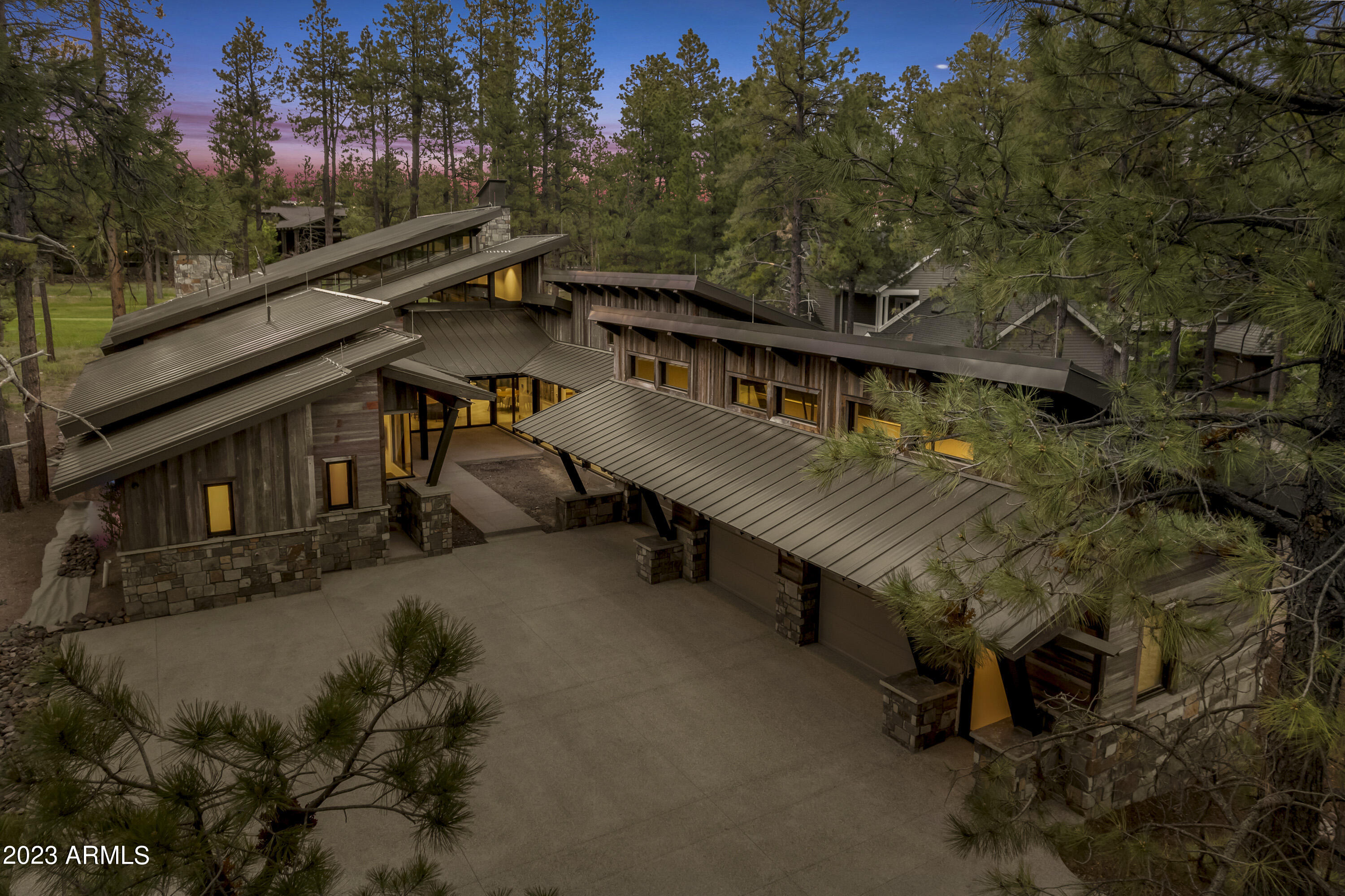 Mountain Modern home in Forest Highlands offering breathtaking golf course views built by Red Rock Custom homes. This luxurious home is equipped with the latest Crestron smart home system, ensuring convenience and automation at your fingertips. Its unique characteristics are accentuated by the use of over 100-year-old reclaimed barnwood from Idaho. The structural integrity is guaranteed with 80,000 lbs. of I-Beam Steel, providing durability, beauty and peace of mind. Step inside and experience the comfort of heated limestone floors that extend seamlessly to the outdoor areas. The metal roof not only adds a contemporary flair but also ensures durability and longevity. Relax and unwind in the 9' x 5' custom built in-ground Jacuzzi, perfectly designed for ultimate relaxation. Stay warm and cozy with the custom masonry fireplaces, adding both aesthetic appeal and warmth on chilly evenings. The 4th bedroom was intentionally built as an open air bedroom/flex room.
This house seamlessly blends indoor and outdoor living with its expansive NanaWall system, allowing for a seamless connection to the surrounding natural beauty. Whether you're enjoying the picturesque views from the comfort of the living room or entertaining guests in the open-air patio, this house is designed to provide an exquisite living experience. Owner is a licensed real estate agent in the state of Arizona.
