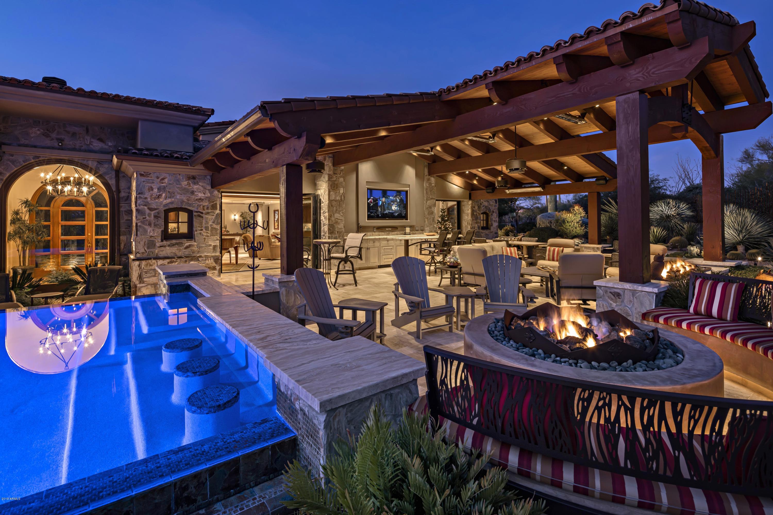 Recently remodeled transitional-style home located on the 9th hole of The Estancia Club with framed Pinnacle Peak views * Open, great room floor plan with connected kitchen and seamless indoor/outdoor living spaces * Fully remodeled outdoor area with a covered ''sports bar'' complete with granite topped bar seating, oversized television, beverage drawers adjacent to multiple fire features, heated pool with swim up bar and spa and a putting green * The main house includes a downstairs master suite and guest suite with a spacious office and state-of-the-art theater upstairs * A separate 2-bedroom, 2 bathroom guest house with living room and kitchenette provides perfect comfort for guests * A 3-car garage completes the residence *