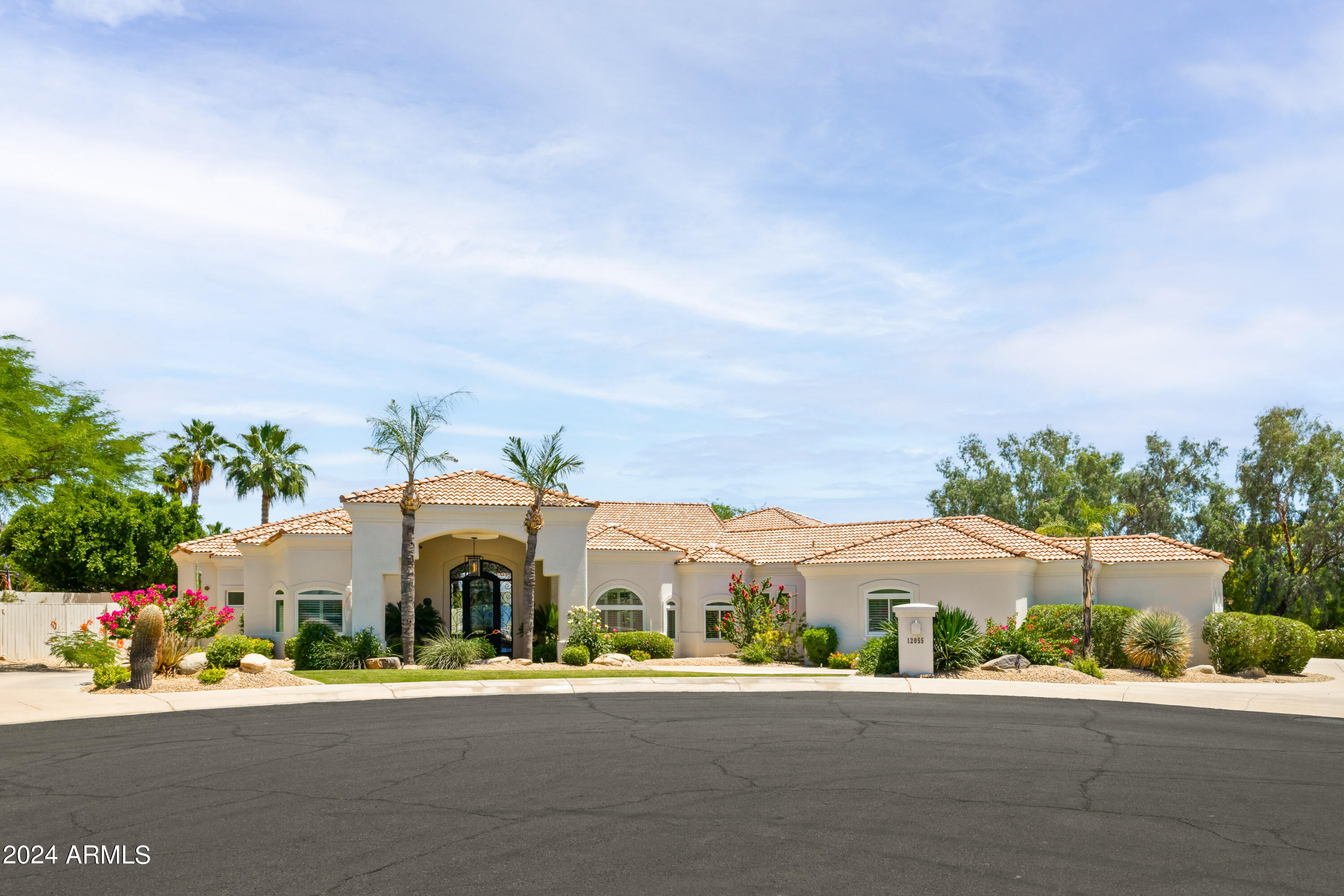 This classic Santa Barbara-influenced residence is nestled at the end of a cul de sac within the lush and maturely landscaped Cactus Corridor in North Scottsdale.  Warmth, light and comfort exudes from the interiors.  Imagine cooking an incredible meal  with your family and friends in the spacious island kitchen  with your favorite tunes playing or watching a game in the great room while serving refreshments at the wet bar.  The dining nook offers a space to read the morning news or enjoy a cafe style lunch or for formal occasions the dining room welcomes holiday traditions.  The primary suite is a retreat-style space with a sitting area, fireplace, French door to the outside and a spa-style bathroom with an impressive walk-in closet. Outside you'll find an oasis front and back with a circular drive and ample parking, a resurfaced pebble sheen pool and rock waterfall, a large covered patio, BBQ area, and multiple seating areas perfect for entertaining.