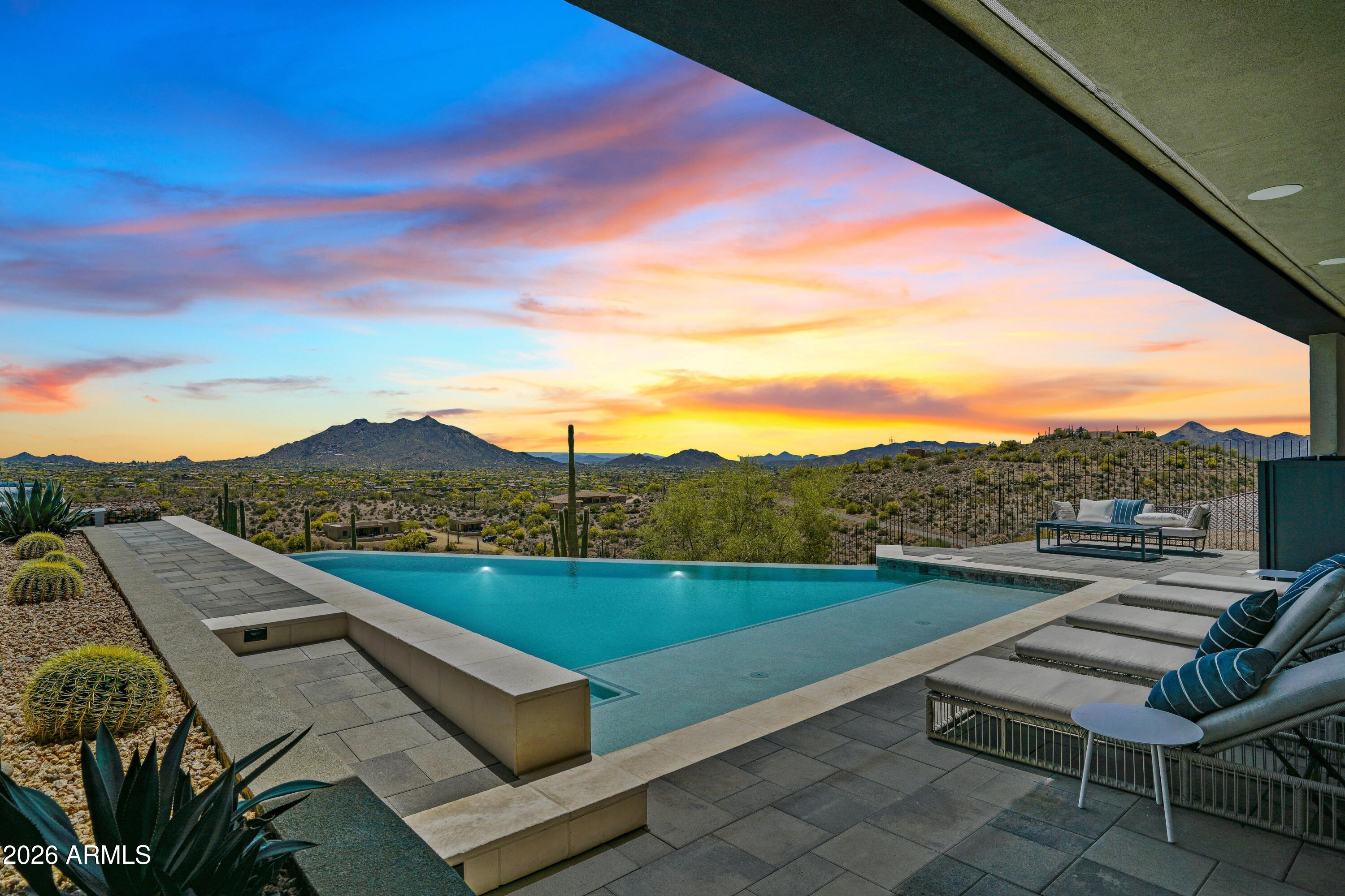 New co-ownership opportunity by Pacaso: Own one-eighth of Desert Haven, a professionally managed, turnkey home. As you ascend the winding driveway, the setting unfolds into a private desert retreat. Positioned on a secluded mountaintop, the home features glass walls, wraparound balconies, a gourmet kitchen and a resort-style infinity pool. Sleek, contemporary architecture emphasizes seamless indoor-outdoor living, beginning in the spacious great room. The gourmet kitchen is equipped with stainless steel appliances and a quartz waterfall island. A formal dining area and executive bar provide ample space for entertaining, complemented by a temperature-controlled whiskey and wine room. The primary suite includes a fireplace, wine fridge and direct access to the patio. The en suite bathroom offers a soaking tub, tiled shower, dual sinks and a makeup vanity. An office and game room open to the infinity pool and patio. The residence includes an elevator and is offered fully furnished and professionally decorated.