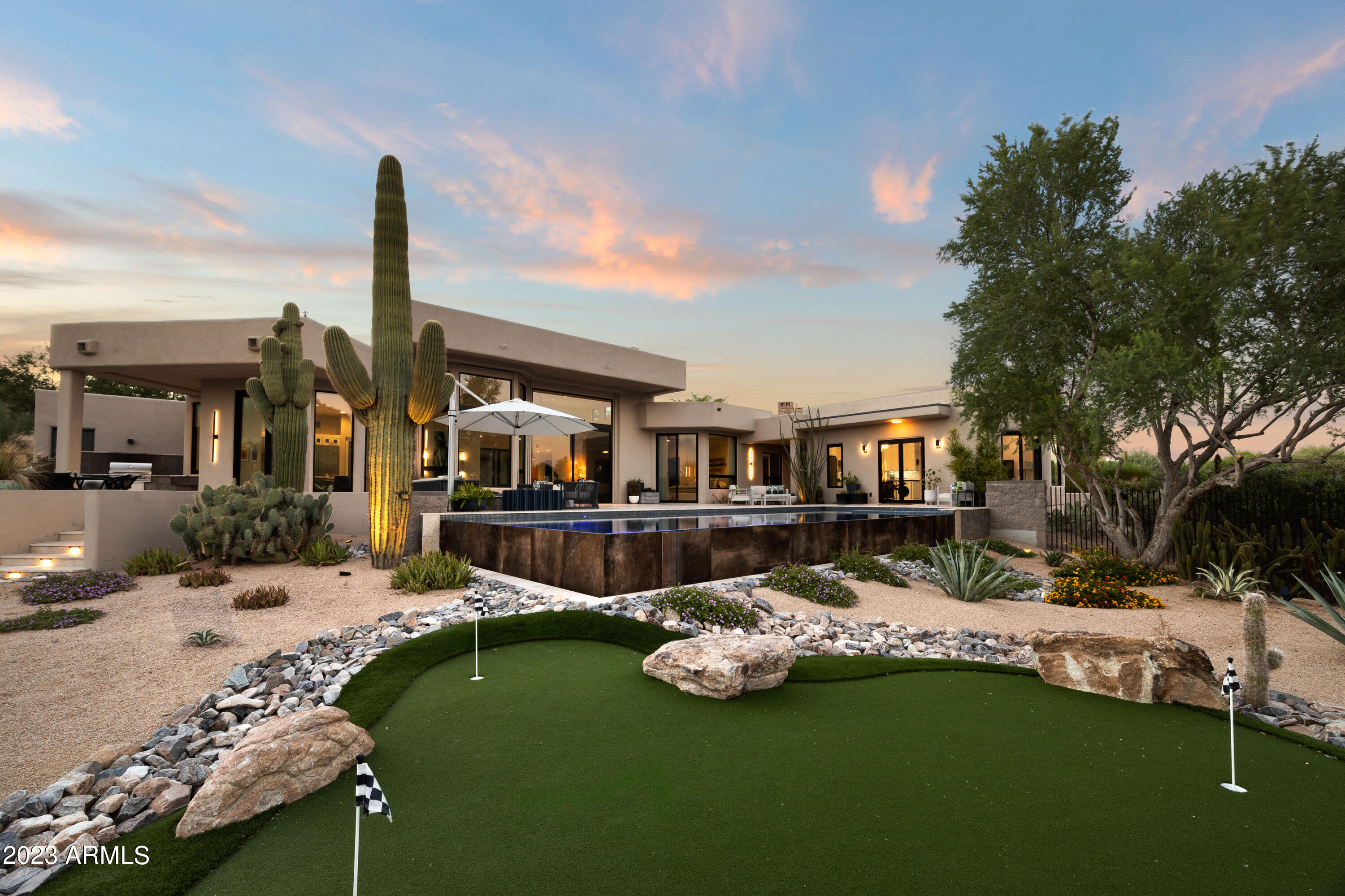 Experience the embodiment of luxury living with this exquisite completely remodeled single-level home (not one interior stair) in Troon Fairways. Overlooking holes 3 and 6 of the private Troon Country Club and boasting breathtaking mountain views of Troon, Pinnacle Peak and McDowell Mountains, this residence offers unparalleled elegance and refined finishes. Enjoy the beauty of Pinnacle Peak at the entrance of the expansive .6-acre property, with soaring ceilings, floor-to-ceiling windows seamlessly blending the stunning outdoor vistas with the interior, and heated bathroom floors. Immerse yourself in contemporary sophistication as you admire the handpicked finishes that perfectly complement the updated style of this home.  Every detail has been meticulously curated from custom wood cabinetry, quartz and Caesar stone countertops, custom built-in closets, primary dressing area, custom tiles, high end plumbing fixtures, to even heated bathroom flooring.  The detached guest house is a true gem complete with a sitting room, kitchen, bedroom, bath, and walk-in closet, offering your guests both privacy, mountain views and comfort. The great room offers a floor-to-ceiling custom Italian tile fireplace, stone hearth and floor-to-ceiling windows that invite the stunning mountains to live within. The custom chandelier at the dining space offers just the right amount of lighting and design to host spectacular dinner parties. The disappearing patio door offers the ideal indoor/outdoor living space to enjoy Arizona weather. The gourmet kitchen offers custom cabinetry, walk-in pantry, gas Wolf 6-burner stove with griddle, GE Monogram refrigerator, warming drawer, Perlick beverage and wine center and microwave drawer where one can cook and entertain for hours, with the outdoor grill kitchen outside at the patio and service window to extend the entertaining to the outdoors.  Step outside onto the inviting stone patios that lead to the mosaic tiled, negative edge heated pool and spa. Entertain in style with an outdoor grill and Green Egg kitchen, a welcoming fire pit, and a covered outdoor living space with even your own putting green. Custom iron fencing gracefully defines the lush desert landscape, inviting leisurely indulgence in your own private resort enclave offering low maintenance landscaping, towering Saguaro cactus and established Ironwood trees with natural shade canopies. The property also boasts a 3-car garage with 220-volt outlet for electric vehicles and ample temperature-controlled storage. Embrace sustainable living with owned solar panels and four Tesla battery packs that enhance your ecological footprint and your lifestyle. Nestled within the prestigious gated community of Troon Fairways in Troon North Scottsdale, this residence promises a life of opulence and refinement that will make you never want to leave the comfort of home.

Review the Features List for the list of finishes for the property in documents tab.