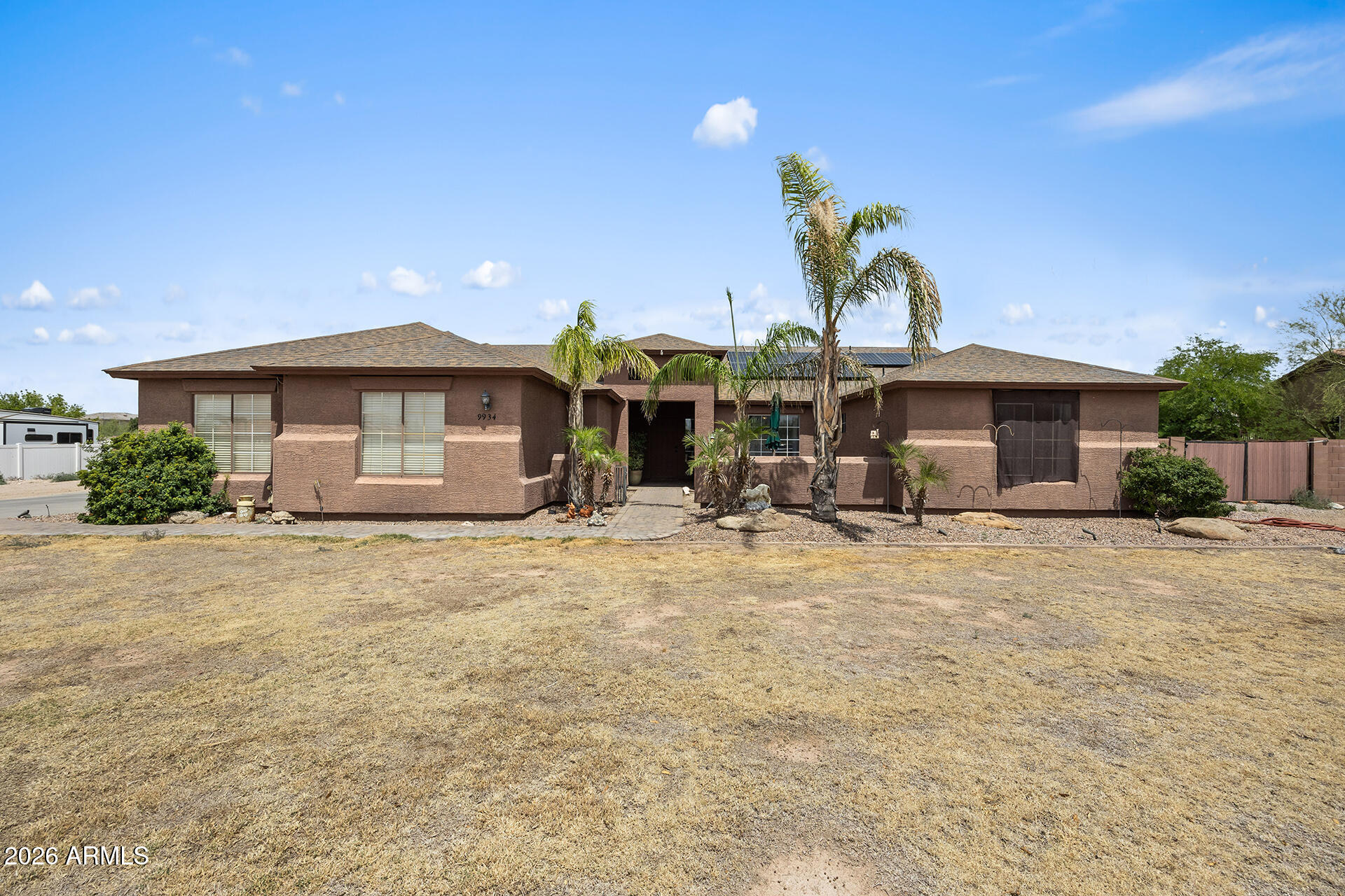 Bring your horses, toys, and dreams - this is country living without compromise! Situated on 1.164 fully block-fenced acres with NO HOA, this spacious 4-bedroom, 3-bath home offers 2,400 sqft of open, vaulted living space designed for comfort and versatility. The split floor plan features a generous primary suite with patio access, while the eat-in island kitchen flows seamlessly into the main living area with a cozy fireplace. Equipped with solar, this property also includes a 3-car garage, detached 1-car garage, RV gate, and a separate workshop - perfect for hobbies, storage, or business needs. With 12' and 5' gates, there's ample room for horses, RVs, trailers, and more. Enjoy a full-length covered patio and breathtaking desert sunsets, all just minutes from shopping, dining, and more!