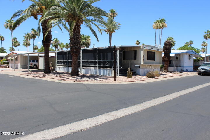 Welcome to easy living in this charming 2 bed, 1.5 bath manufactured home located in a  55+ community! Situated on a spacious corner lot, this home offers side-by-side parking for added convenience. Enjoy relaxing mornings or entertaining guests on the huge porch, plus an inviting Arizona room perfect for year-round enjoyment. Inside, you'll find a comfortable layout with plenty of natural light and space to make your own. A wonderful opportunity to enjoy comfort, community, and the Arizona lifestyle!