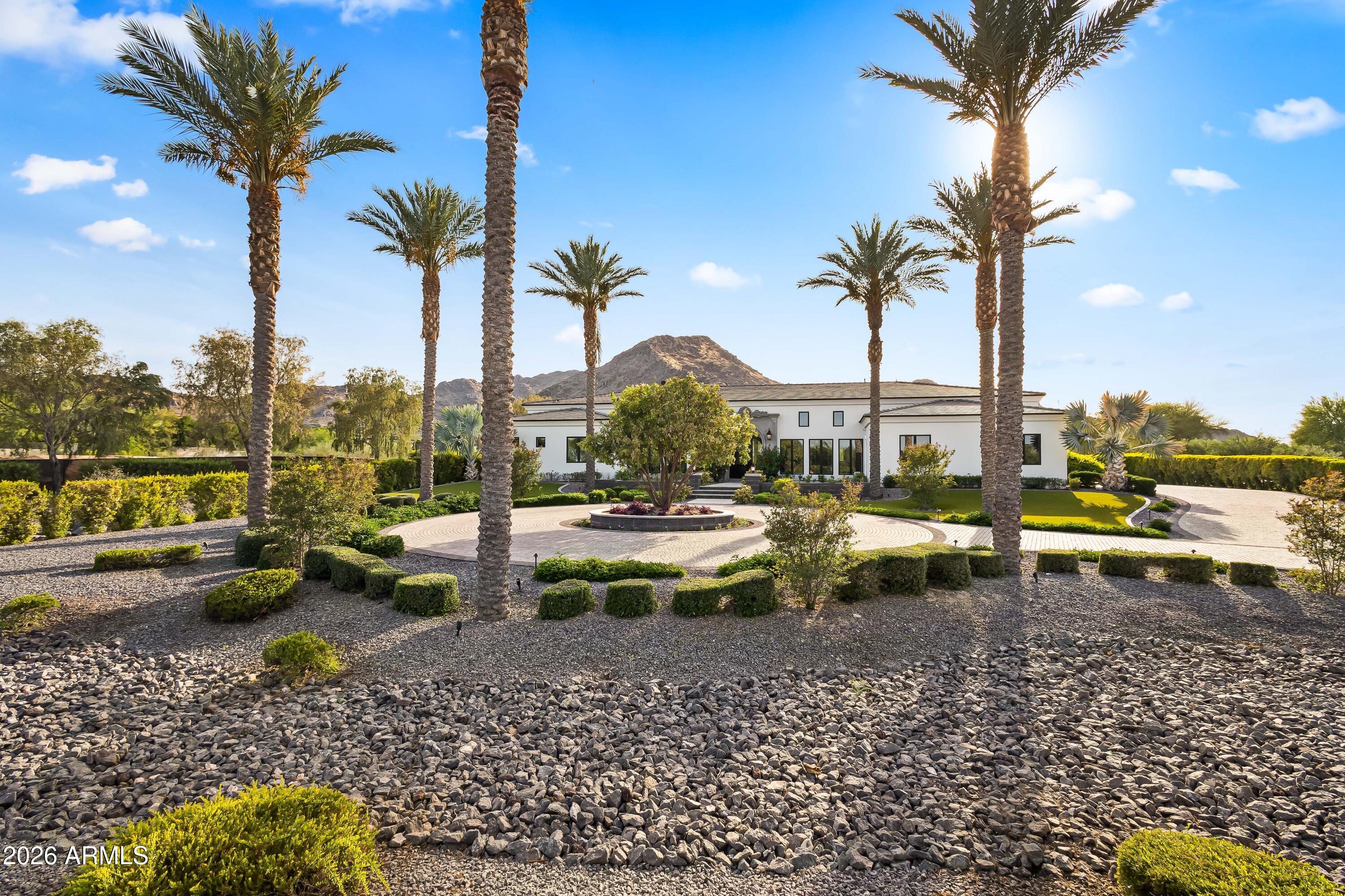 Nestled at the base of iconic Mummy Mountain, this exceptional Paradise Valley estate sits on over 1.25 acres in one of the Valley's most coveted enclaves, within the highly sought-after ''3 C's'' school district. Spanning nearly 7,000 square feet, the home seamlessly blends timeless elegance with modern comfort.The residence features 5 spacious bedrooms including guest house, 6.5 bathrooms, a richly appointed office with custom built-ins and paneled walls, and a versatile bonus room ideal for a gym, theater, playroom, or additional workspace. A striking checkered foyer welcomes you into soaring ceilings, dramatic designer lighting, and abundant natural light throughout. The open-concept great room, anchored by a gas fireplace and framed by French doors, flows effortlessly into the chef's kitchen-complete with large center island, high-end appliances, casual dining, and a formal dining space. A butler's pantry enhances functionality with a Miele coffee system and wine refrigeration. The primary suite offers a private retreat with sweeping mountain views and direct backyard access. The spa-inspired bath features dual vanities, a freestanding soaking tub, oversized walk-in shower, dual private water closets, and dual custom walk-in closets. Outdoors, the property unfolds into a resort-style setting designed for relaxation and entertaining. The expansive grounds showcase a sparkling saltwater pool and spa, multiple lounge areas, and a custom outdoor fireplace, all oriented to capture stunning mountain views and Arizona's signature sunsets. Additional highlights include a 3-car garage and a Crestron Home system providing seamless control of lighting, climate, security, and entertainment. Ideally located near premier destinations such as Camelback Mountain and Sanctuary Camelback Mountain, this home offers convenient access to world-class golf, hiking, fine dining, and upscale shopping.