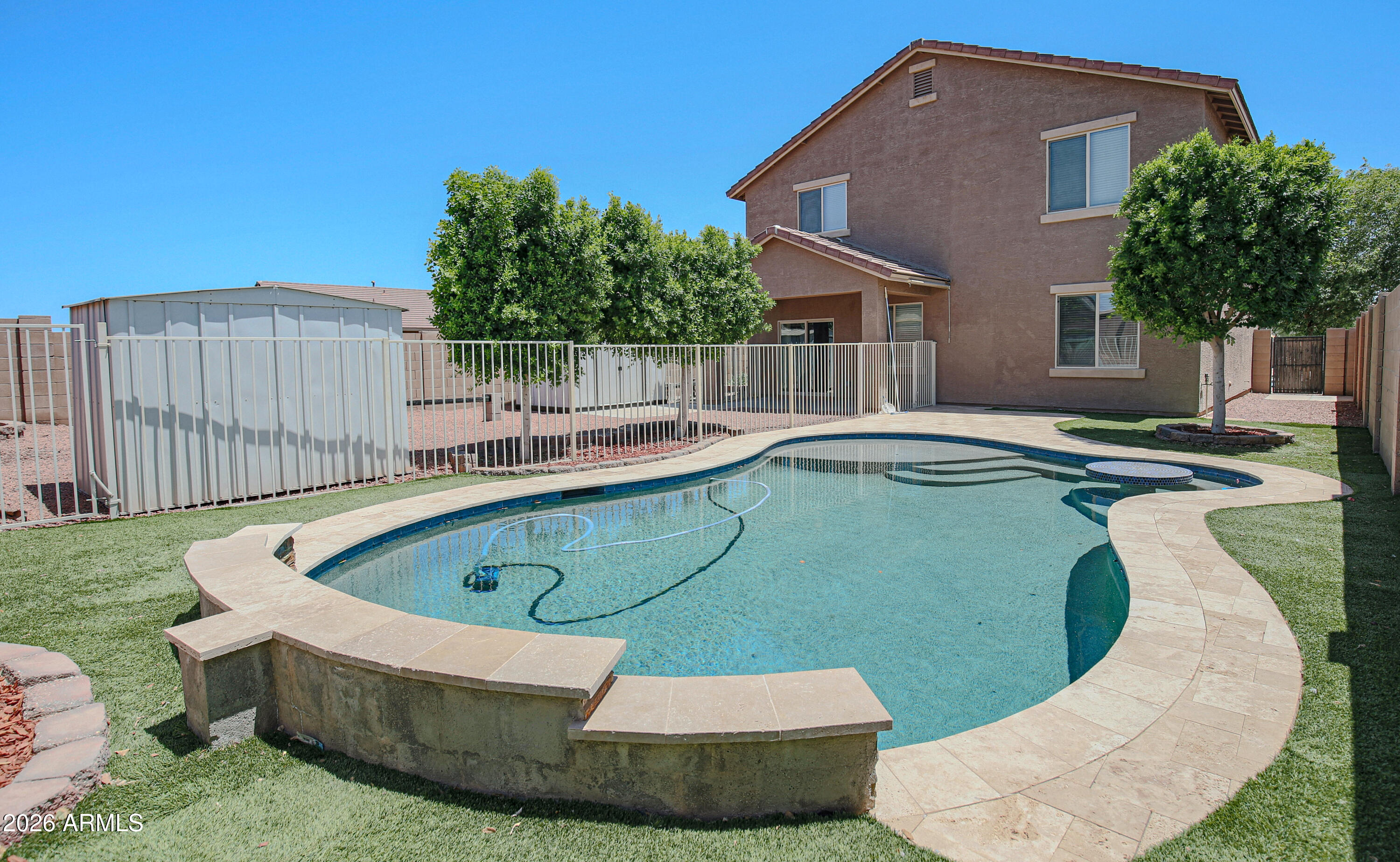 Resort-style living meets energy efficiency SOLAR OWNED OUTRIGHT and a sparkling pebble-sheen pool. This spacious 5 bed, 3 bath home offers a flexible layout. The main-level has a bedroom and full bath ideal for multi-gen. living, plus a Den/ Office.  The spacious kitchen has granite tops, large island, R.O. and pantry.  Upstairs features 4 bedrooms, 2 baths, and a loft/ theater room prewired for surround sound.  Stylish upgrades include vinyl luxury plank flooring throughout (NO CARPET) and 4'' baseboards. The primary suite is spacious, the bathroom offers a separate tub and shower.  Enjoy the entertainer's backyard with a gorgeous pool, travertine decking and low-maintenance synthetic grass and gravel. The Community offers parks, playgrounds, a basketball court.
