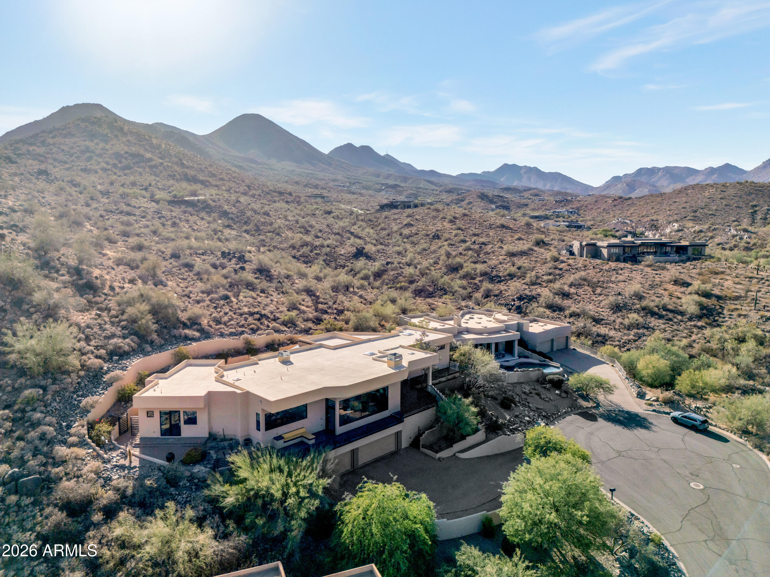 Perched on a quiet cul-de-sac in Fountain Hills, this exceptional luxury residence offers nearly 4,000 square feet of refined living with breathtaking views of Four Peaks, Red Mountain, Troon, and the iconic Fountain. Designed for both comfort and sophistication, the home features a spacious split floorplan, soaring ceilings, and dramatic floor-to-ceiling windows that frame the surrounding desert landscape. An elevator provides seamless access between levels, enhancing both convenience and accessibility. The gourmet kitchen is a true centerpiece--complete with custom cabinetry, recycled glass countertops, a large island with beverage cooler, induction cooktop, double ovens, and a large walk-in pantry--flowing effortlessly into the expansive Great Room with fireplace and built-in surround sound. The private primary suite offers direct access to outdoor living spaces, along with a spa-like bath featuring dual vanities, soaking tub, walk-in shower, and generous closet space. Each additional bedroom includes its own ensuite bath, walk-in closet, and private outdoor access--ideal for guests. Journey outside to a resort-style backyard with a saltwater pool, waterfall feature, and covered patio, perfectly positioned to capture Arizona's stunning sunsets and mountain views. Additional highlights include a dedicated office, oversized laundry room, and a three-car garage--all showcasing meticulous attention to detail throughout.