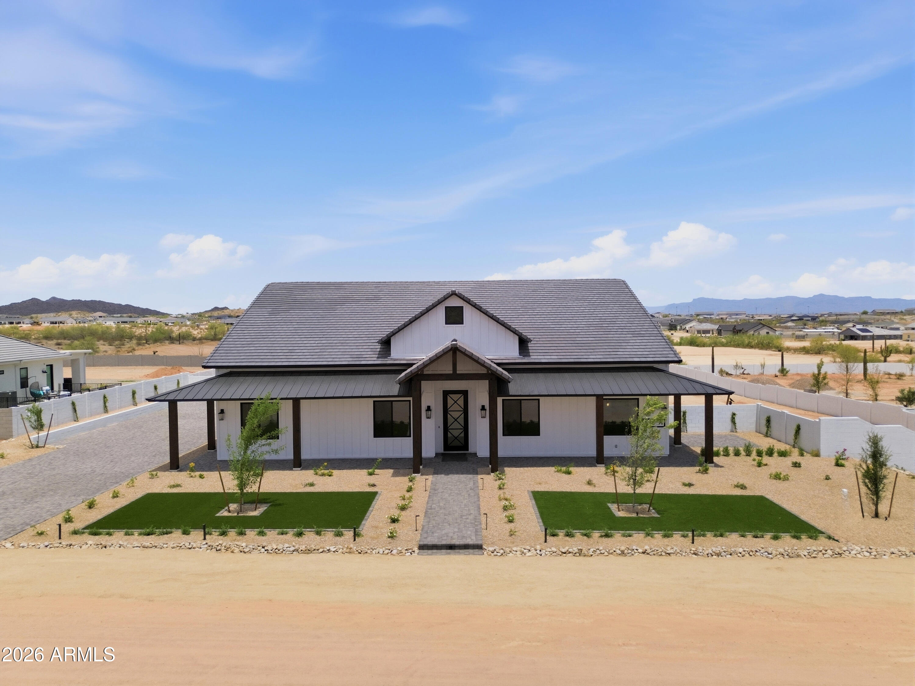 Experience luxury desert living in this exceptional ranch-style estate offering 4 bedrooms, office, 3.5 baths, and 3,792 SF on 1.344 acres. Designed with exceptional craftsmanship, this home features Andersen windows, 10' sliders, spray foam insulation, quartz countertops, custom tile, soaring 12'-14' ceilings, beam details, and a chef's kitchen with premium appliances, three ovens, and a butler's pantry with an additional sink and dishwasher. Resort-style primary suite with a private sitting area, dual closets, stacked laundry, and spa shower. Oversized 4-car garage with 18'x10' doors, polyaspartic floors, side-mount openers, Navian tankless water heater, EV charger, Trane ACs, metal/concrete roof, wraparound porch, outdoor shower, block wall, iron gates, and beautifully landscaped.