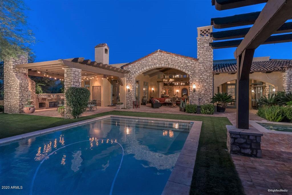 Discover ultimate craftsmanship in the Country Club neighborhood of DC Ranch! Meticulously constructed by acclaimed builder Tom Archer, this Mediterranean-inspired masterpiece exudes the perfect blend of old and new. Extensive wood detailing and stonework found throughout make this property timeless. This 7,002 sq. ft. home features 5 bedrooms, exercise room and loft -- all but one bedroom on the main level. The well-appointed and updated kitchen is connected conveniently to two sizable entertaining areas, including the vaulted great room featuring a zinc serving bar, stone walls and electronic pocket doors which bring the outdoors in. Other highlights include a 500 bottle walk-in wine room flanking the private dining room, eight limestone fireplaces and uniquely designed bathrooms throughout. The garden-like backyard is lined with trees and mature vegetation, and anchored by a decorative pool/spa. Two distinct outdoor living zones--a covered TV patio with fireplace and a BBQ patio with trellis cover--provide excellent spaces for gathering and enjoying the Arizona weather. Bordering the perimeter of DC Ranch affords distant views of Pinnacle Peak and immediate McDowell Mountain panorama.