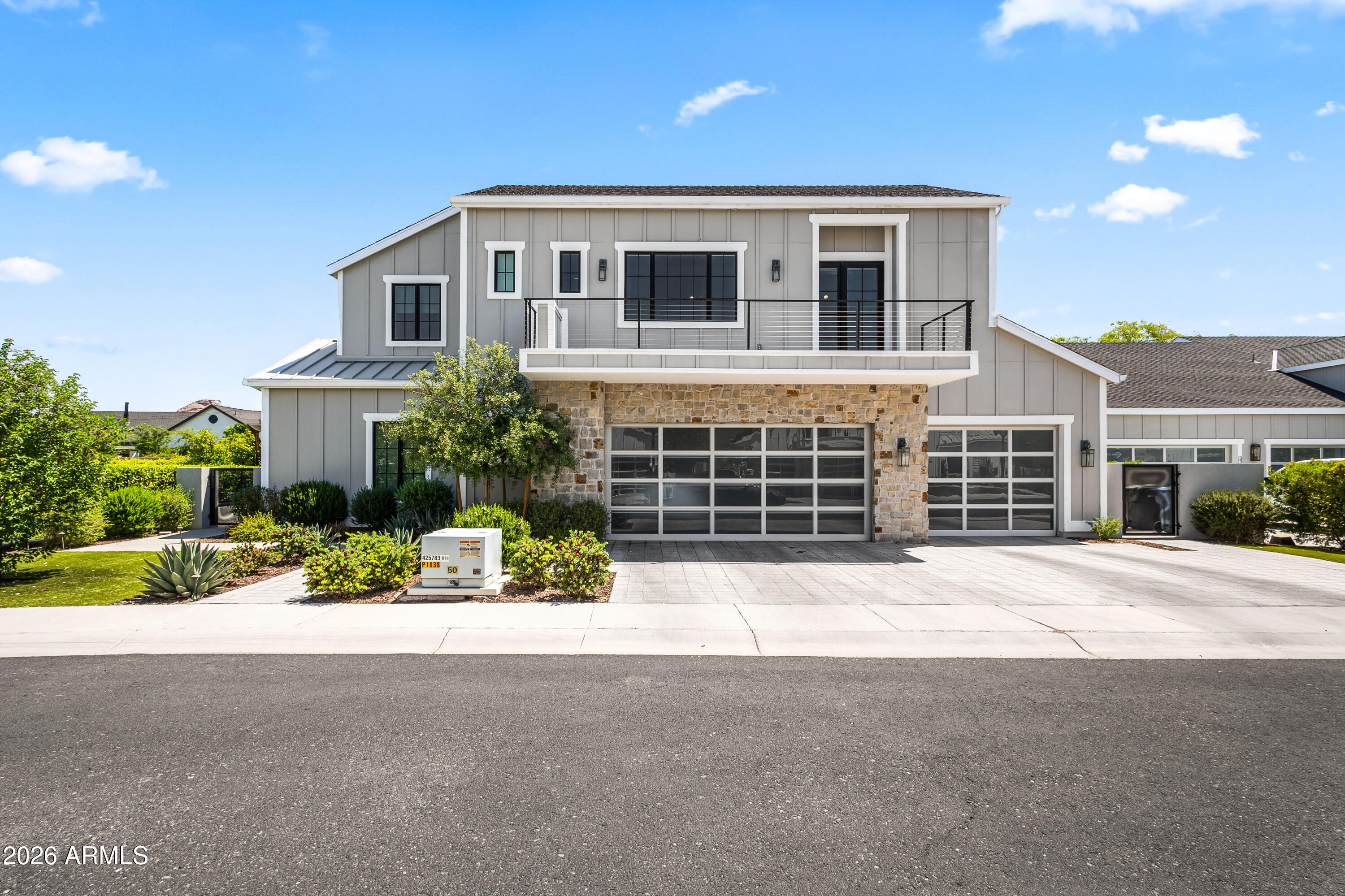 Located within the exclusive gated enclave of The Sycamore, this stunning two-story custom modern farmhouse offers refined living in the heart of Arcadia. Thoughtfully designed for both style and livability, the home features soaring ceilings, expansive open entertaining spaces, and high-end finishes throughout. White oak wood flooring flows seamlessly through the main living areas, including a living room with a fireplace and custom built-ins, as well as a great room highlighted by a paneled ceiling. The gourmet kitchen is outfitted with top-of-the-line Sub-Zero and Wolf appliances, custom cabinetry, and a well-appointed butler's pantry--ideal for both everyday living and entertaining. The luxurious primary suite features a spacious walk-in closet and a spa-inspired bath. Each guest bedroom is designed as a private ensuite with its own walk-in closet, offering comfort and convenience for family and guests. Upstairs, a large game room opens to a private deck with scenic views, creating the perfect space to relax or entertain. The backyard is designed for seamless indoor-outdoor living, complete with a covered patio, custom heated saltwater pool with swim jets, spa, built-in BBQ, and a grass yard framed by mature landscaping. Additional highlights include a 3-car garage and separate storage area. Ideally located just a short walk or bike ride to Arcadia favorites like LGO and Postino, and close to Arizona's premier resorts, golf, fine dining, and shopping, this home offers an exceptional blend of luxury, location, and lifestyle.