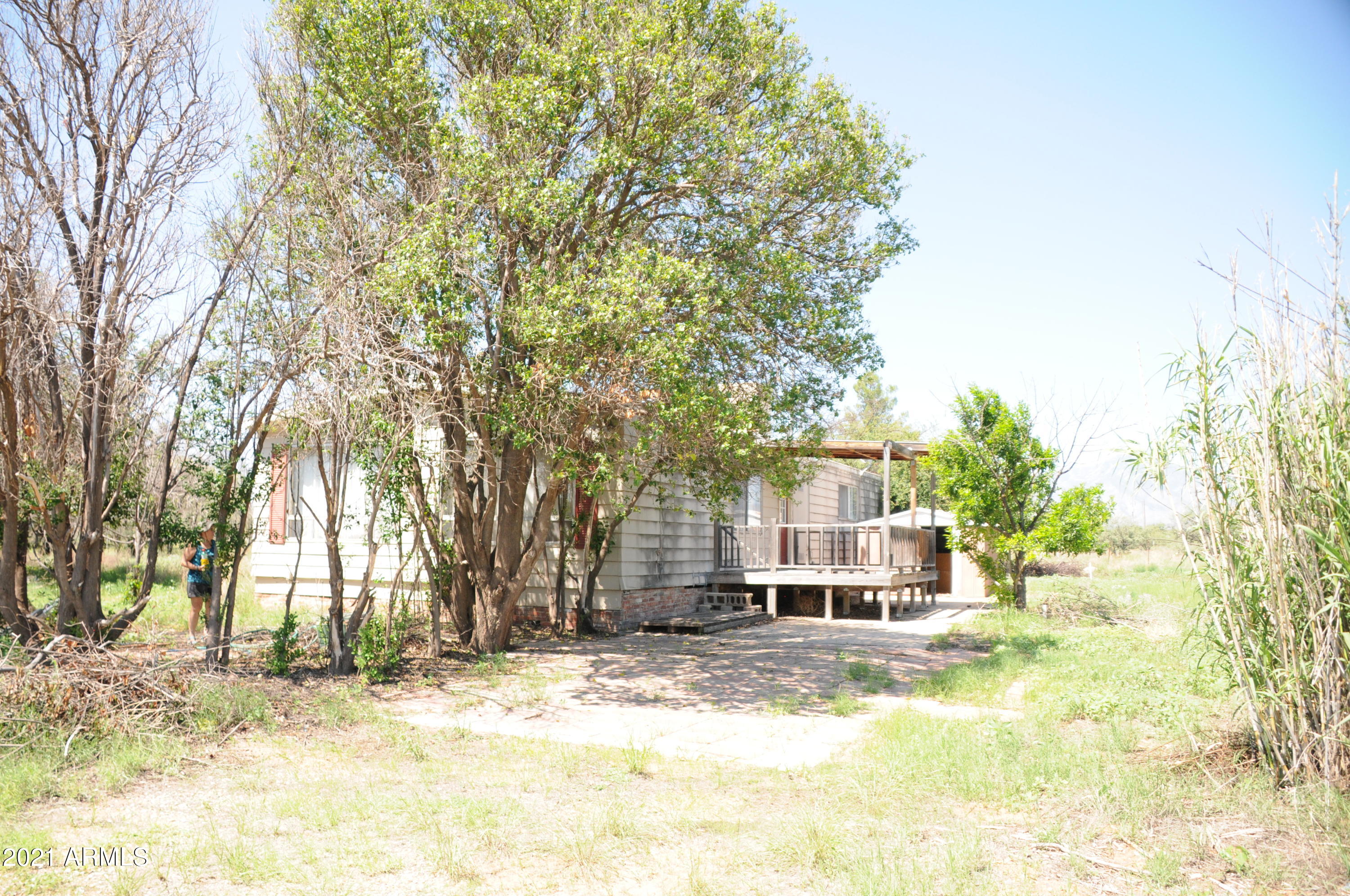 Property is priced for land only. Home has been vacant for years. It is attached to the property, but conveys with no warranty, guarantee or value. Property has horse facilities, and large grazing pasture that is fenced. Fence has old electric top wire. Pasture has it's on large gate (trailer size). Entire property is fenced. There are two storage sheds, a well house and access to a alley/utility easement. In the feed/tack room are three saddle racks. There are some items left on the property that buyer will have to deal with. Seller is unable to deal with removing them. Septic has just been pumped and inspected. Electric and water are on. Private well. There have been deer, javalina and quail while I was there.