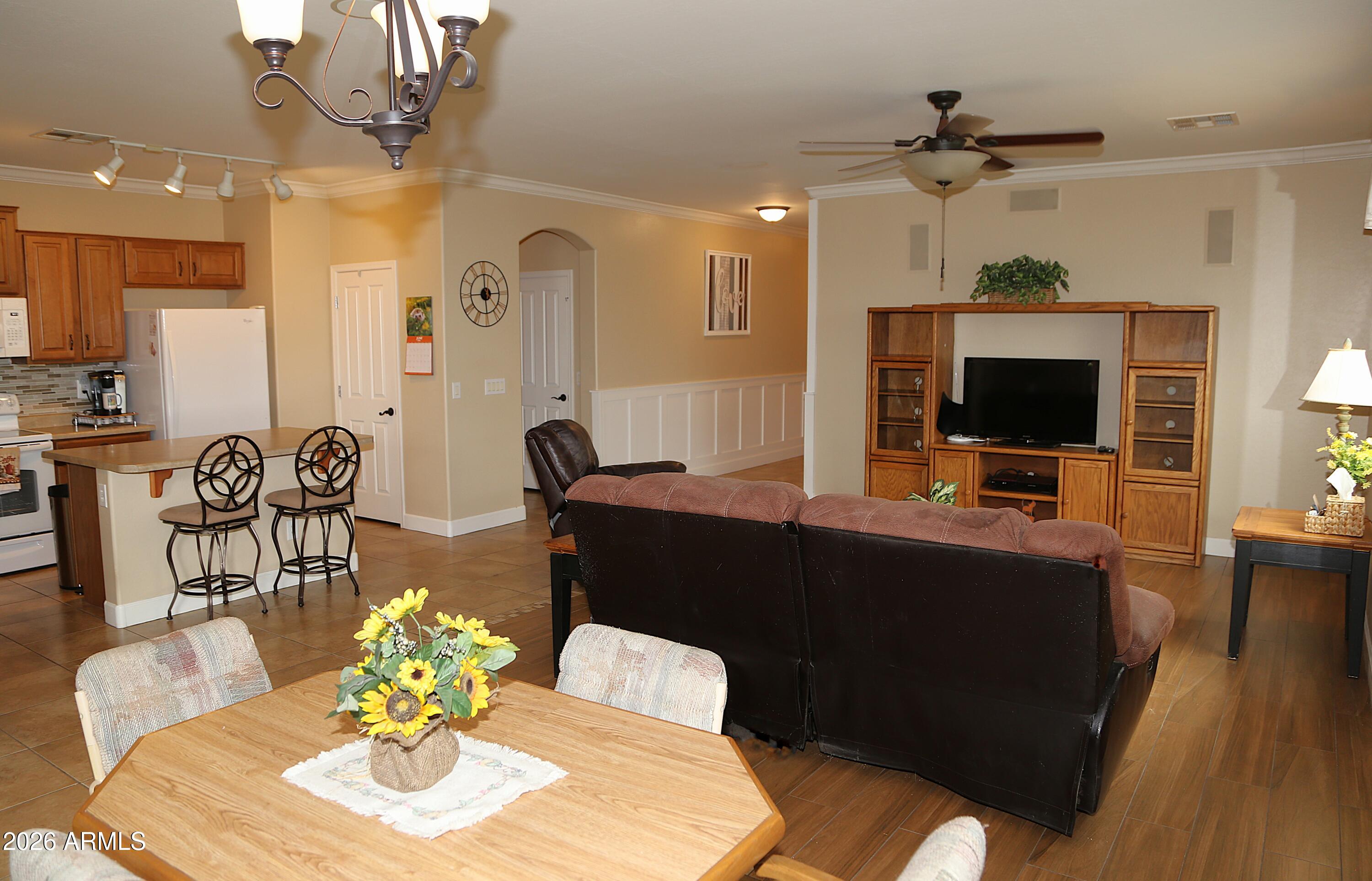 Owned Solar! Welcome to this 3 bdrm/ 2 bath home located in Cooley Station! Embrace the split floor plan that enhances privacy and flow, and a kitchen adorned with a stylish updated backsplash and a central island for added convenience.  The primary bathroom features a renovated shower and a spacious walk-in closet offering ample storage. The guest bathroom includes its own linen closet, ideal for organizing all your towels and extra storage. Step outside to find a lush green backyard with no neighbors behind, ensuring your outdoor space remains serene and private. This property does have newer owned solar panels and owned water softener. Enjoy the community pools and parks. Nearby you will find grocery stores, plenty of restaurant options, a movie theater and Mesa Gateway Airport