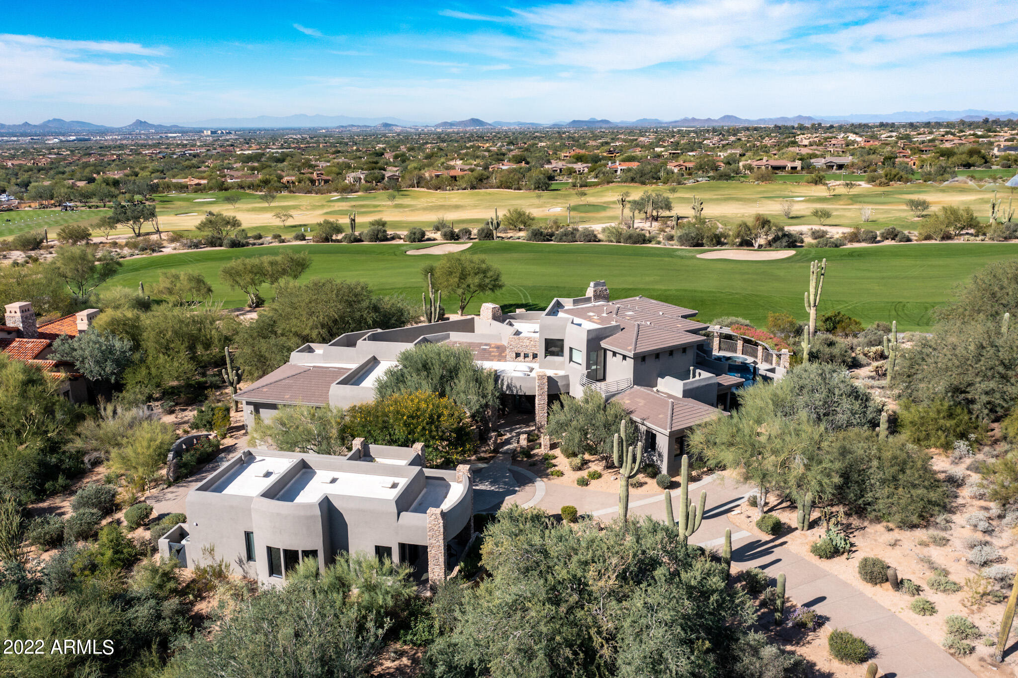 Desirable Calvis Wyant custom estate on the coveted 10th fairway of The Country Club at DC Ranch golf course, boasts postcard worthy southwest city, golf, and sunset views from virtually every room. Stunning arrival with circle drive, separate guest house, one of a kind custom artistic concrete/glass front door, and dramatic first impression views.  Pristine modern estate with newly remodeled eat-in kitchen claims serene lush golf course views with chic current details.  Functional living spaces with limitless opportunities, with 4 bedrooms, plus 800 sq ft two room guest house, expansive theatre/flex room, wine room, and second level office and primary suite with scenic panoramic view balcony with amazing mountain and canyon golf views.  Tranquil resort style back yard with wrap around expansive covered patio, offers spacious entertaining areas with two fireplaces, pool/spa, lounge areas, and BBQ grill.  Sought after guard gated community in the heart of North Scottsdale, with community amenities, hiking, golf, shopping, restaurants, and schools minutes away.  Suitably situated for club members with a short stroll to the clubhouse.