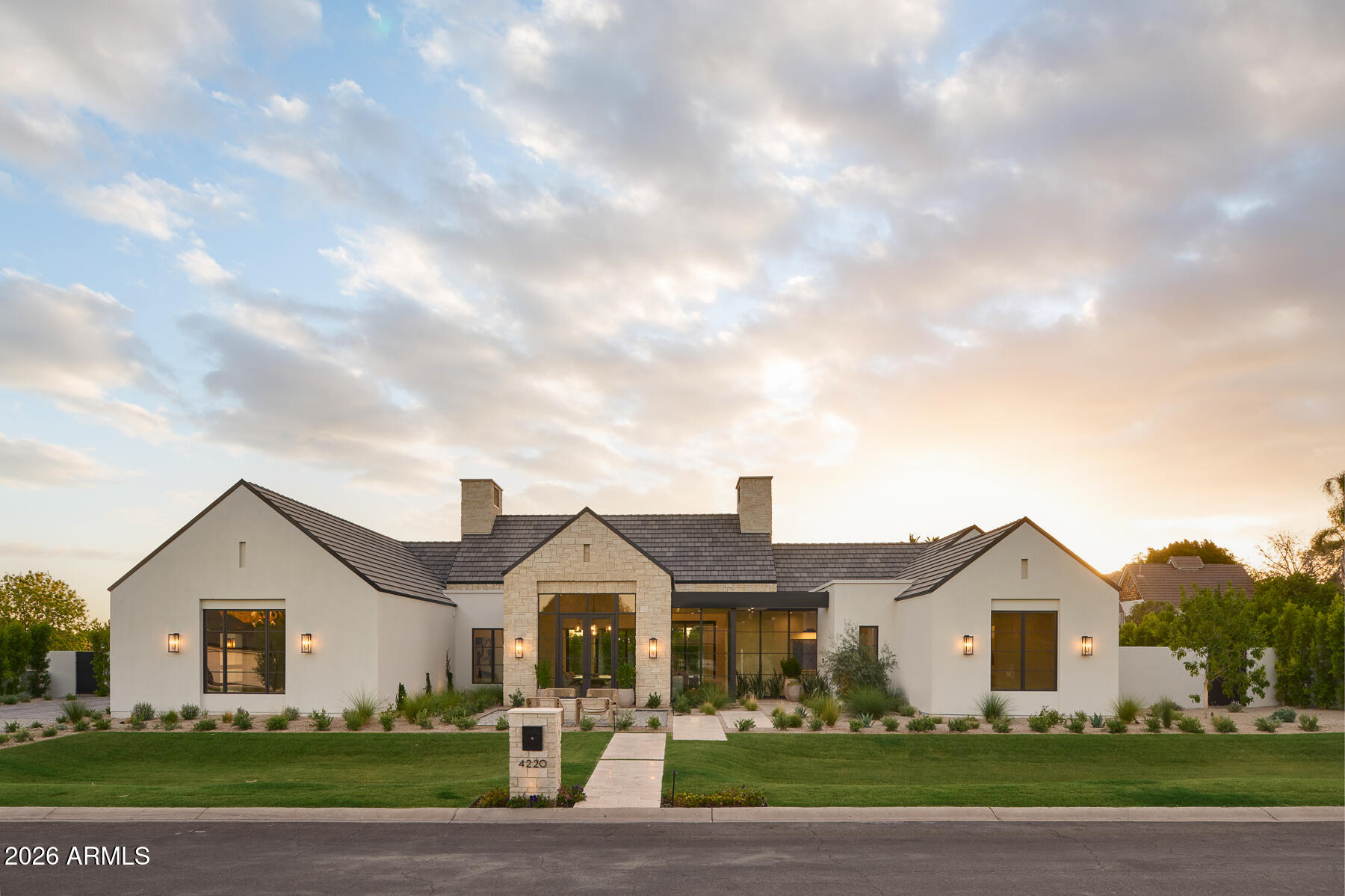 This contemporary design blends seamlessly with the surrounding Arcadia neighborhood while maximizing glass and true indoor-outdoor living. Set on a rare half-acre lot with no visible power lines, the home captures stunning Camelback Mountain views from nearly every angle. Built and designed by award-winning Rafterhouse, recognized for its level of craftsmanship and design, with architecture by Damon Wake of Studio Wake, no detail was overlooked in the craftsmanship and execution of this 5,933 sq ft residence, inside and out.

The home offers 4 en-suite bedrooms with oversized walk-in closets, a powder bath, office, and gym. Inside, soft natural stone introduces warmth and texture, coming to life under evening lighting, while expansive living, dining, and kitchen spaces are finished with top-tier materials, including a Wolf and Sub-Zero appliance package. The kitchen is complemented by a back kitchen and built-in coffee station, while a separate bar creates a true indoor-outdoor entertaining experience, complete with extensive wine storage, an ice maker, and dishwasher & beverage drawers. Hedged site walls and curated landscaping by Roots First provide privacy and continuity, anchored by a resort-style pool. All just minutes from Arcadia's best dining, shopping, and schools.
