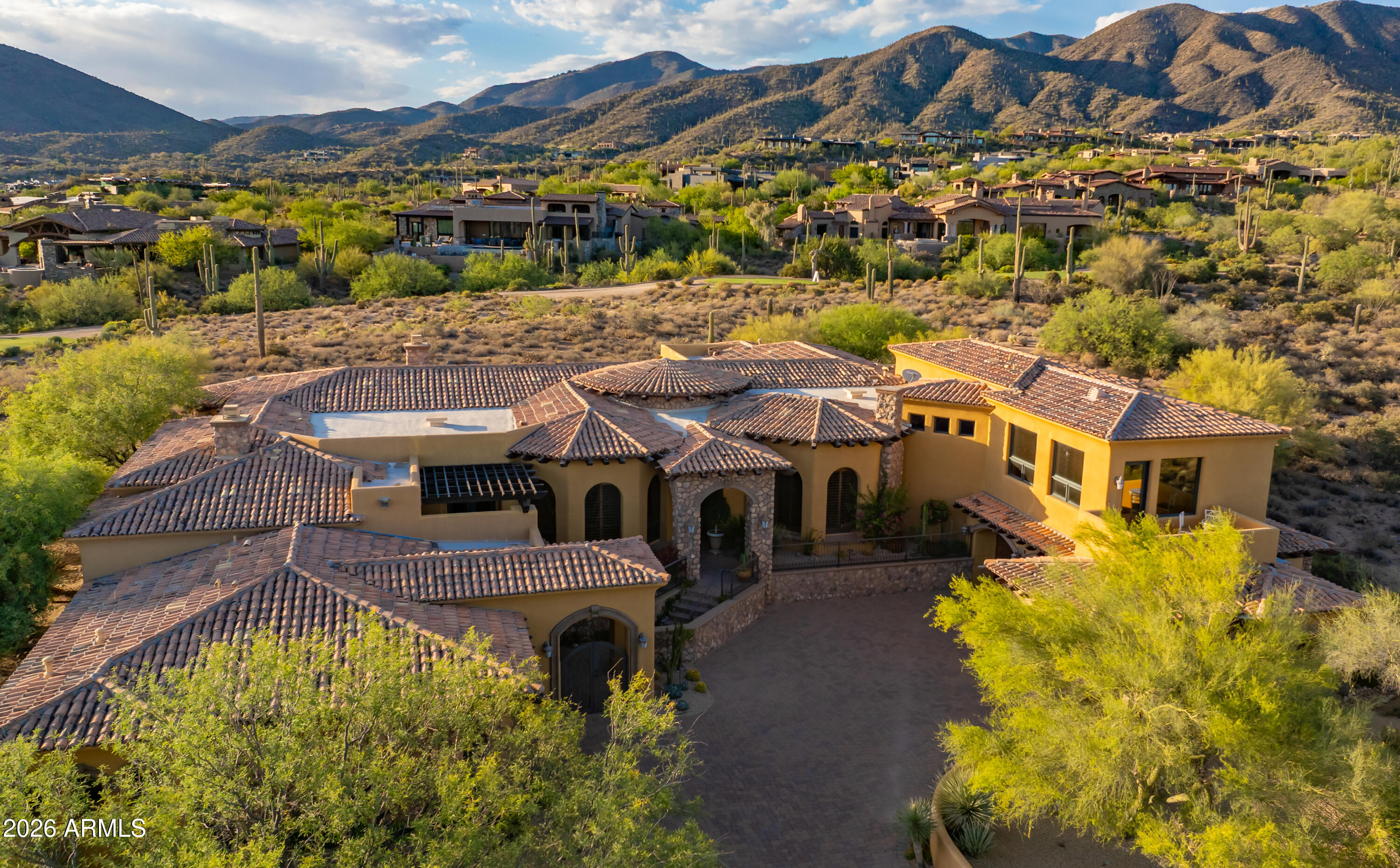 **GOLF MEMBERSHIP AVAILABLE.** Tucked within Desert Mountain's prestigious double-gated Saguaro Forest Village, this extraordinary estate captures a rare balance of elegance, artistry, and timeless design--an exceptional residence defined by craftsmanship and refined living. Perfectly sited on a private golf course lot, it offers sweeping views of the desert, surrounding mountains, vibrant sunsets, sparkling city lights, and the fairway beyond.
Recently refreshed with interior and exterior paint, the home is complemented by lush yet low-maintenance desert landscaping and a thoughtful floor plan that seamlessly blends formal living with flexible spaces for today's lifestyle. Rich materials--including extensive travertine, granite, and bespoke cabinetry--create a warm, sophisticated atmosphere throughout. At the heart of the home, the chef's kitchen is both functional and striking, appointed with double Sub-Zero refrigeration, a Wolf range, double dishwashers, double ovens, and generous prep and gathering space ideal for entertaining at any scale. The primary suite is a private sanctuary, featuring dual baths and closets, along with an intimate sitting room anchored by a fireplace and framed by serene golf course views. Additional living spaces include well-appointed ensuite guest bedrooms and a spacious bonus/game room complete with wet bar, view deck, and panoramic mountain and city-light vistas. A detached-style guest casita--complete with private entrance, kitchenette, full bath, laundry, and its own garage--offers elevated comfort and privacy for visitors or extended stays. Outdoors, the experience continues with a resort-style setting designed for effortless Arizona living: a pool and spa, built-in BBQ, and expansive travertine patio provide the perfect backdrop for both quiet relaxation and unforgettable entertaining.