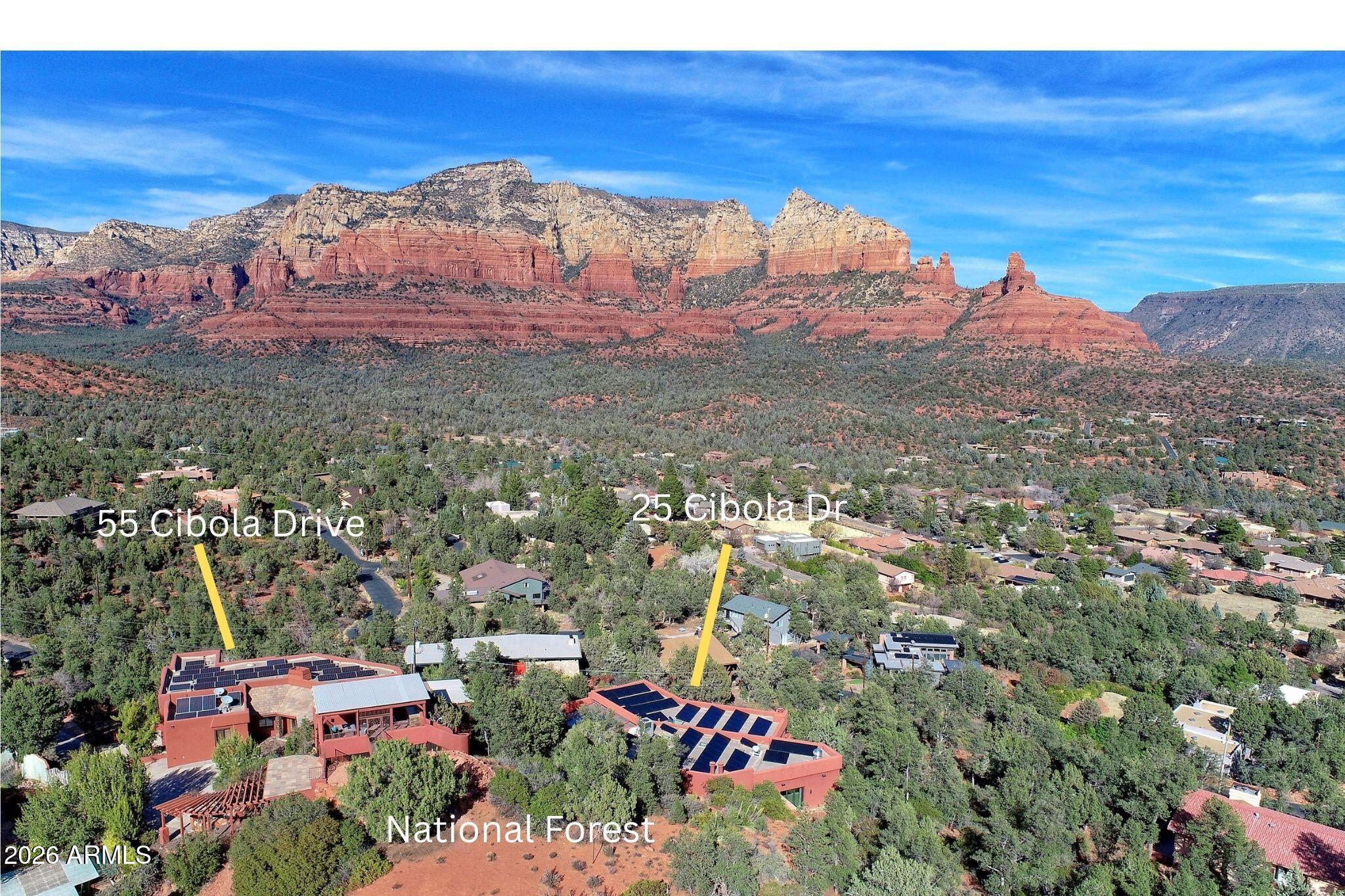 Welcome to La Aguilera: Sedona's Rare, True Two-Home Compound. This isn't a house.
It's a private Sedona compound: 2 architecturally distinct luxury residences on 2 separate parcels, sold together, bordering National Forest, w/ red rock views that don't blink.
If you've outgrown the idea of ''one big house'' & want privacy, flexibility, & legacy-level ownership, this is the play.  Perched in Uptown Sedona's coveted Cibola Hills, La Aguilera delivers what sophisticated buyers  actually want: separation without sacrifice, comfort without compromise, & a setting that feels protected from the world:  not staged for it.
Together, the estate spans approximately 9,723 square feet, thoughtfully divided across two homes, each w/ its own personality, purpose, & WOW factor. 25 Cibola: Entertainer & Wellness Residence
Approx. 6,146 sq ft
This is the social anchor of the compound built for hosting, celebrating, and living large without ever feeling loud.
A dramatic atrium entry sets the tone, blending Southwest character with elevated craftsmanship. The lower level offers a guest ensuite, a gym or secondary guest suite with wet bar and fridge, and direct access to the showstopper: a convertible indoor/outdoor pool designed for year-round Sedona living. Mosaic tile, pebbled lighted water wall, elevated spa: it's resort-level, minus the resort.
Upstairs, the Great Room opens under pitched wood ceilings with exposed trusses, wood floors, and a desert-toned brick fireplace. Walls of glass pull in red rock views to the north and Mogollon Rim light to the east. The massive east-facing deck becomes the afternoon ritual: cocktails included.
The primary suite is calm, private, and unapologetically comfortable, with dual granite vanities, waterfall shower, jetted tub, and space to actually exhale.
The chef's kitchen is built to perform: granite counters, custom wood cabinetry, KitchenAid appliances, breakfast bar, and a walk-in pantry with prep space that understands scale.
Then there's the 1,575 sq ft Party Room: a rarity even by Sedona standards. Twelve-foot ceilings, built-in speakers, professional bar, stone fireplace, room for dining, music, billiards, and real gatherings. When the weather shifts, the indoor commercial grill and private patio keep the night moving.
Add owned solar, elevator, multiple HVAC zones, remote shades, security system, fire safety infrastructure, and direct access to world-class hiking and biking trails and you start to understand why this home works as hard as it relaxes.

55 Cibola | The View House & Wine Sanctuary
Approx. 3,577 sq ft
This residence is quieter. Sharper. Designed for evenings, sunsets, and serious wine.
Custom hardwood floors, soaring ceilings, and expansive glass frame Sedona's most iconic red rock formations. The Great Room centers around a smoky brick beehive fireplace with an Alligator Juniper mantle: dramatic, grounded, unforgettable.
Step onto the main deck or ascend to the covered SKY deck for true 360-degree views. Sunrise. Sunset. Night sky. Repeat.
The primary suite is a private retreat with walk-in closet, dual vanities, separate tub and shower, and a custom red rock mural. Outside, a private hot tub waits because it should.
Downstairs offers a bonus living room or office, laundry, storage, and garage access. 
The Wine Spectator-featured wine cellar is one of the most distinctive in Sedona. Gated by wrought iron, introduced by a water feature and live grapevines, carved into native red rock walls, and secured with inventory sensors. Stained glass accents complete the atmosphere. It's equal parts art installation and serious cellar.

Why This Compound Works
" Two homes. Two parcels. One legacy estate.
" Ideal for multi-generational living, long-term guests, staff, or owners who value separation.
" Live in one. Host in the other. Or simply enjoy the luxury of space done right.
" National Forest boundary, protected views, Uptown convenience without Uptown chaos.
La Aguilera isn't for everyone & that's exactly the point.
This is Sedona ownership for buyers who've already done "impressive" and are ready for intentional, private, and lasting.