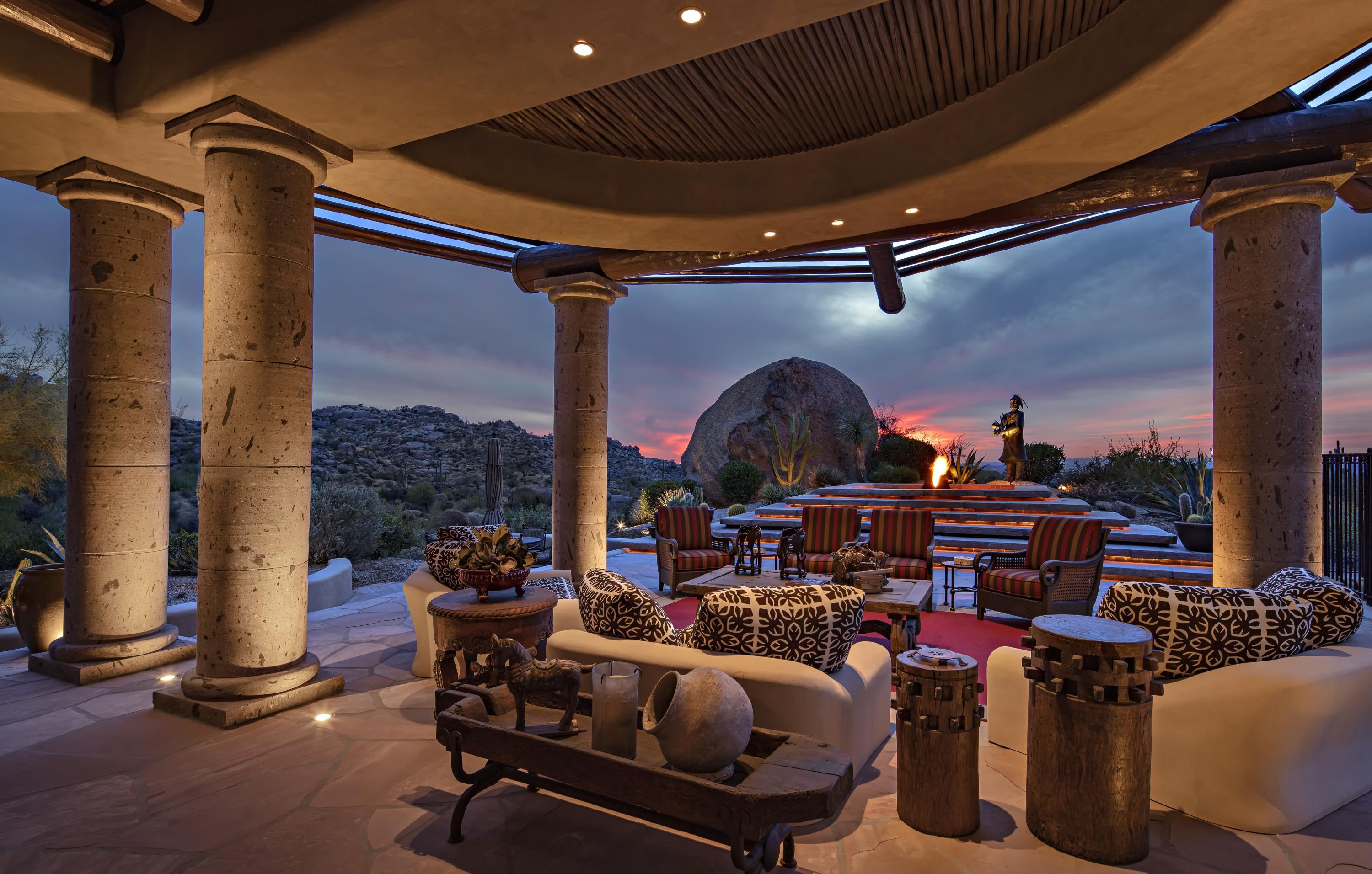 **RARE OPPORTUNITY** PURCHASE THIS HOME AND AN ESTANCIA MEMBERSHIP IS AVAILABLE. (Subject to board approval) A secluded compound like no other—-this Estancia estate home and guest house were designed by the awarding winning team of Bob Bacon, Designer and Teresa Delellis, Decorator and was awarded the 2002 Home of the Year by Phoenix Home & Gardens.  The thoughtfully designed car pathway from the street to the home provides an arrival journey through mature landscape and over a vine-covered bridge to the formal car park. The front gates open to announce you are entering a 'special place' with a beautifully landscaped courtyard and several spring fed ponds.  The home has been immaculately maintained and presents as new with the highest quality craftsmanship and detail.  All of the surfaces have been meticulously curated throughout the home and include flagstone and cherry wood flooring, cantera stone walls and columns, custom carved cabinetry details and venetian plaster walls. The estate includes a very livable 8,400 sf of living space with 1,400 sf allocated to the guest house providing a total of 4 bedrooms, a gorgeous Master Suite with artistic entrance, sitting area and fireplace, a Jr. Master Suite with fireplace that guests adore, all bedrooms contain large, luxurious en-suite baths. Additionally, the home has three half-baths, a dramatic living room with wet bar, formal dining room, warm family room that is open to a stunning kitchen featuring an oversized butcher block island and finally, a country club-quality exercise room with great outside views and mirrored walls. Ten gas fireplaces in the home and outdoor areas provide further entertaining drama. The three car garage is fastidiously detailed with a tile-finished floor and large bays. The home contains six outside sitting areas three of which are covered, a heated, negative edge pool with spa, a built-in BBQ and dramatic vistas of Pinnacle Peak, golf course and sunsets.

An architecturally unique-generational home provides the perfect venue for gracious living, memorable entertaining and hosting life's most special moments.
