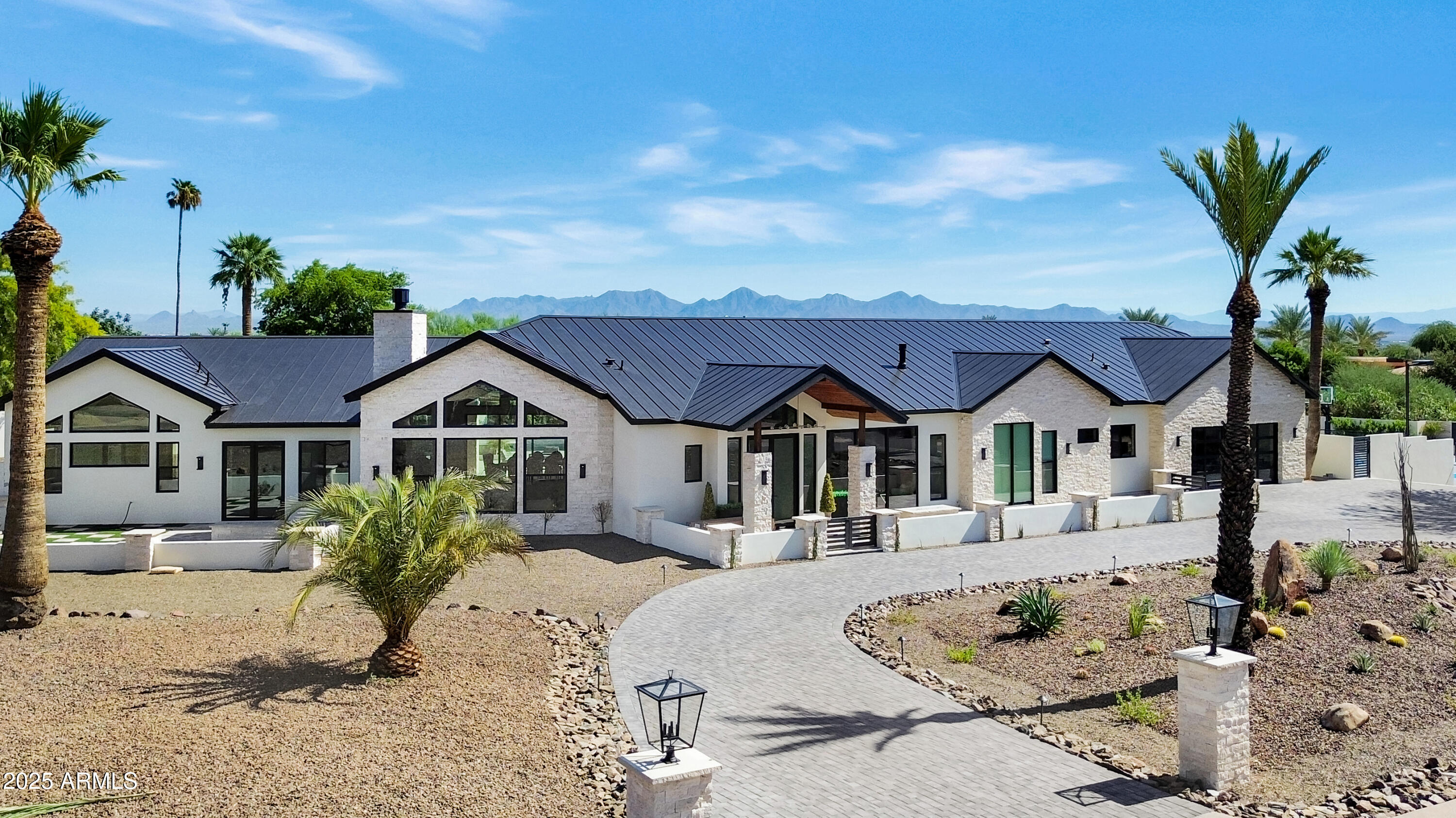 Introducing this exceptional newly constructed estate, nestled on the prestigious Sage Drive in Paradise Valley. Thoughtfully situated to showcase unobstructed views of iconic Camelback Mountain, this home seamlessly combines timeless architecture with refined modern luxury in one of the Valley's most coveted locations.

Inside, herringbone-patterned oak wood flooring flows gracefully throughout the main living areas, bringing warmth, texture, and timeless elegance to the expansive interior. Two commanding fireplaces framed in black marble serve as dramatic anchors, infusing each space with architectural refinement.
The heart of the great room features a massive 72-inch Summit Open Luxury Fireplace, a showpiece that combines cutting-edge technology with luxury ambiance. Custom rift-cut white oak cabinetry, highlighted by antique brass and matte black hardware, speaks to a curated designer aesthetic throughout.

The chef's kitchen is a visual and functional masterpiece, outfitted with top-tier Sub-Zero and Wolf appliances, honed oyster white marble countertops, and seamless rift-cut white oak cabinetry. A spacious butler's pantry ensures ample prep and storage space, perfect for daily functionality or large-scale entertaining.
An adjacent wet bar with Subzero wine fridge, clad in matching oyster white marble and designer finishes, provides the perfect complement to the kitchenideal for hosting with ease and elegance.

The primary suite is a tranquil retreat, centered around a cozy fireplace wrapped in black glazed fluted ceramic tile. It boasts an expansive walk-in closet and a spa-like bathroom featuring marble flooring, walls, and seamless slab shower surrounds.

Each additional bathroom continues this elevated design, incorporating all matching marble countertops, slab feature walls, and thoughtfully selected fixtures that blend modern luxury with enduring appeal.



Step outside and experience a true resort-style retreat. The backyard is an entertainer's dream, complete with a sparkling pool and spa, private tennis/pickleball court, and multiple gas firepits. A built-in BBQ with marble countertops and stacked stone details enhances the outdoor kitchen area, while the dramatic pergola framed by stacked stone columns and a striking 3D wave stone feature wall adds architectural distinction. Travertine and paver hardscaping seamlessly unify the outdoor spaces with sophistication and function.

Situated in the heart of Paradise Valley, this estate offers the perfect balance of privacy, luxury, and convenience just minutes from world-class resorts, fine dining, upscale shopping, and premier golf. With breathtaking views and exceptional design throughout, this one-of-a-kind property redefines desert living at its finest.