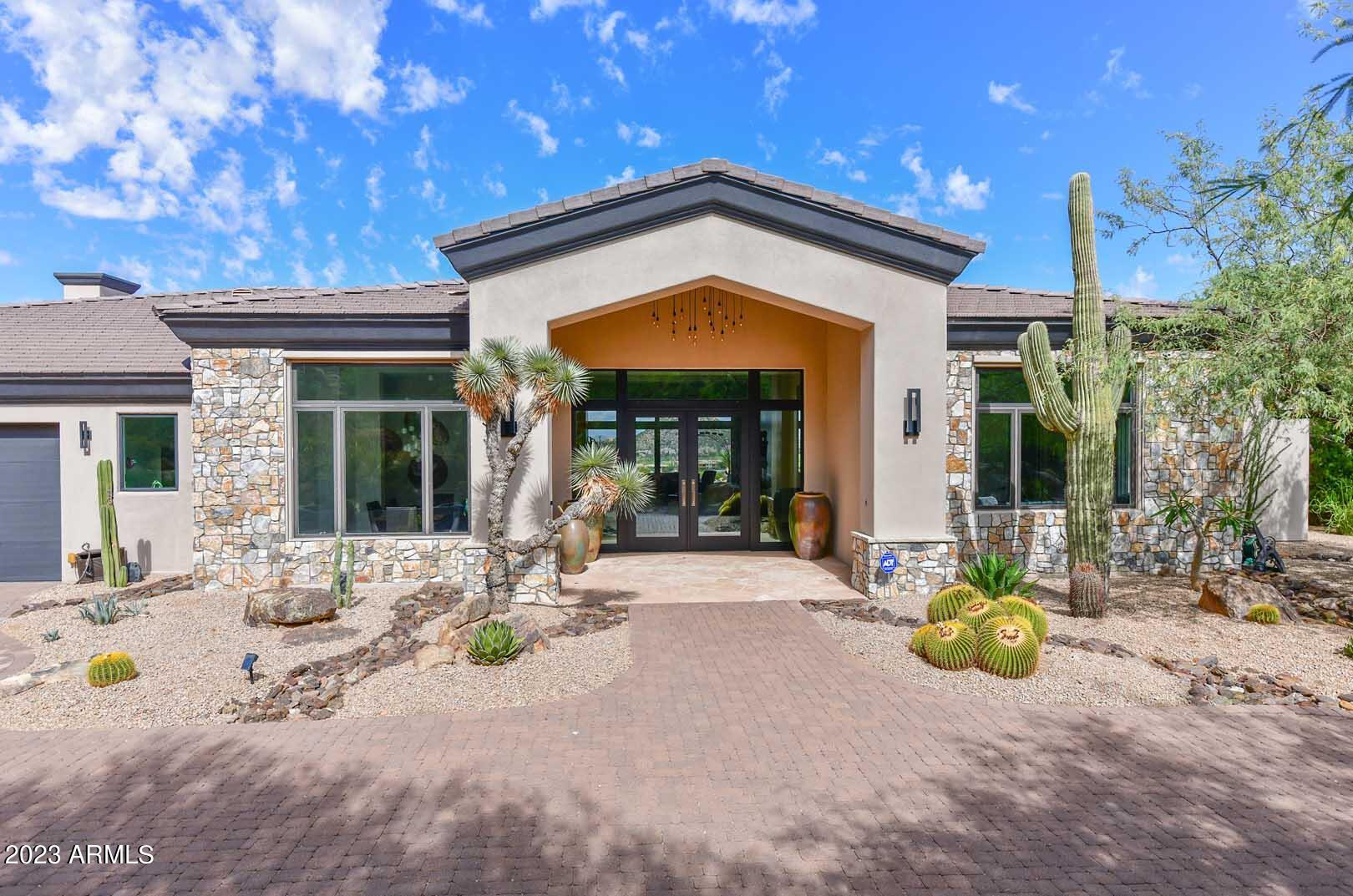 Nestled on a tranquil 1.5-acre single-level hillside lot, this fully remodeled home invites you to bask in uninterrupted mountain views from every room. The modern kitchen boasts Neolith countertops, Wolf and Subzero appliances, and double ovens. Designer finishes include European white oak engineered hardwood floors, natural stone, and porcelain tile. Outside, an entertainer's paradise awaits with a negative edge pool, cascading waterfall, spa, and built-in barbecue. A 500 sqft casita with a kitchenette adds versatility to this remarkable property. Discover the pinnacle of Arizona living. The 1 acre lot below the home (11087 E Troon Mountain Dr) is also owned by the seller. Lot is not in the MLS.