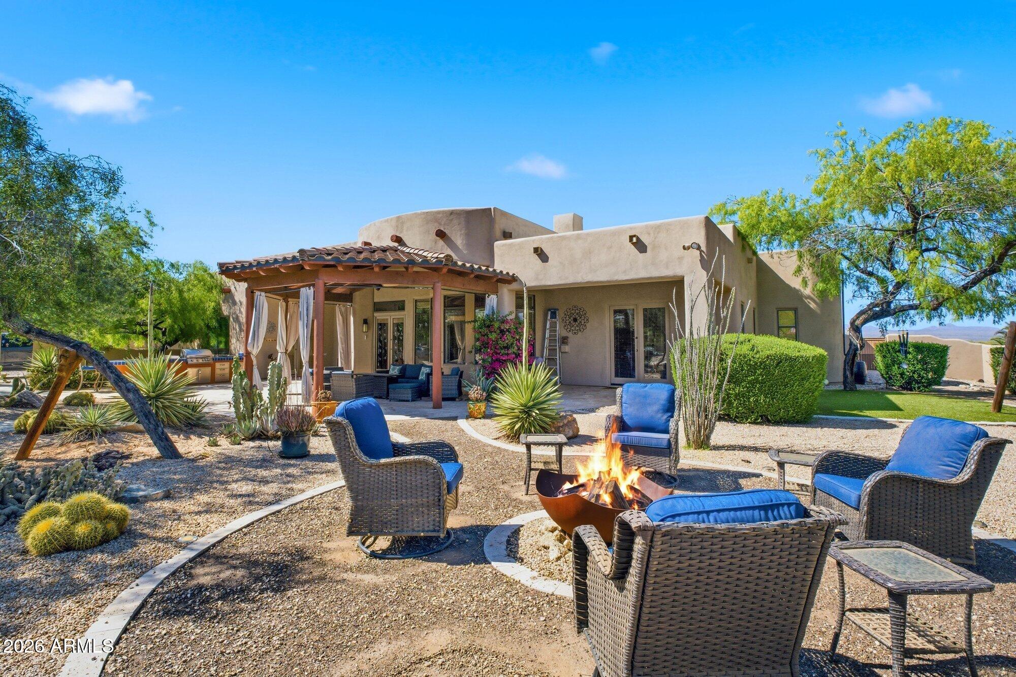 Custom Santa Fe-inspired home on 1.25 ac in the Rio Verde Foothills. 3,251 SF main home + ~800 SF casita w/ full kitchen & living. EPCOR WATER! 5BR/4BA, hand-crafted alder doors, hammered copper sinks, granite, vaulted ceilings, chef's kitchen, formal dining, great room. Block-walled yard w/ resurfaced saltwater pool, slide & cascading waterfall on boulder feature, covered patio, fully equipped outdoor kitchen, rattlesnake-sealed. Comprehensive 2022-2026 systems overhaul: full Pentair pool (heat/cool pump, auto system, VS pump, filter), 3 new HVAC, recoated roof, fresh paint, water softener, tank pump & bladders, irrigation panel, garage door system, smart thermostats, new appliances. Walk to McDowell Mtn Preserve-Granite Mtn, Brown's Ranch, Tom's Thumb, Fraesfield. Turn-key Sonoran luxury