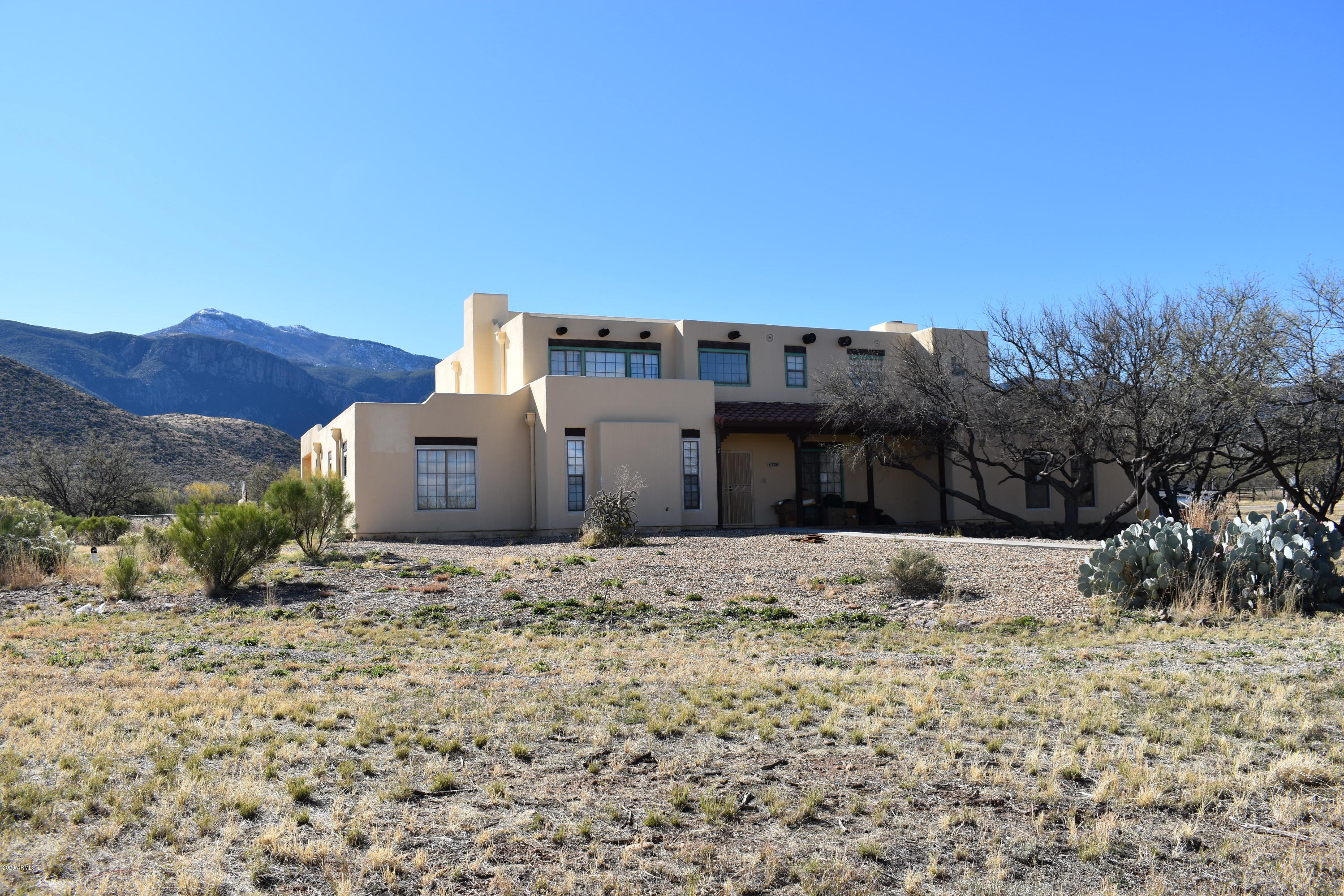 Large Sante Fe style home on over 2 acres. This home is located in a luxurious neighborhood at the base of the Huachuca Mountains.
Large open living room with vaulted ceilings and fireplace. The second story is dedicated to the master suite and a loft/office area. Although the home is in need
of some TLC from a new owner it has a lot of potential to be your dream home