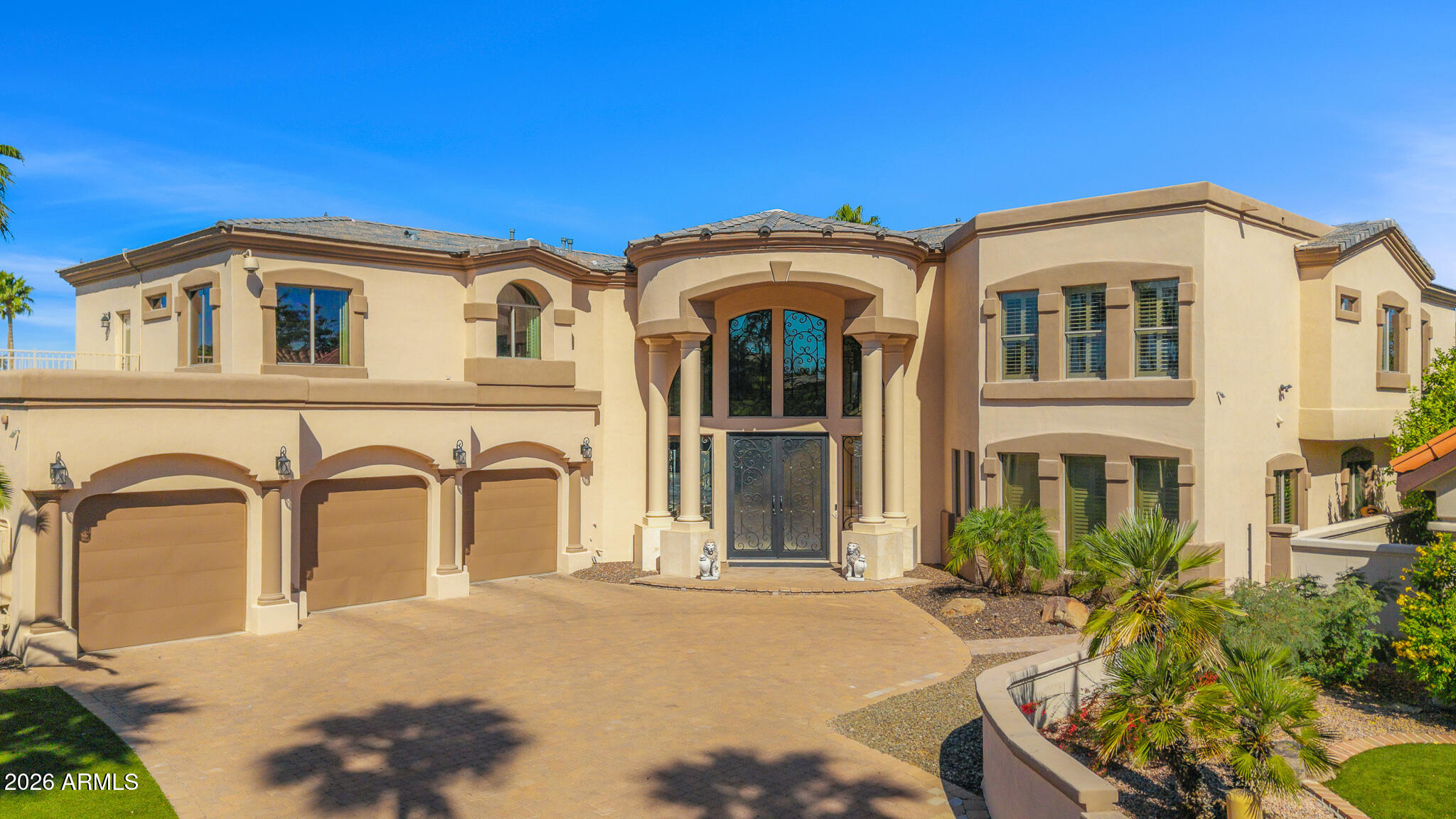 Experience a rare lakeside lifestyle in the desert within the gated community of West Lakes Estates. Tucked at the end of a quiet cul de sac, this timeless estate captures sweeping lake views and unforgettable Arizona sunsets, creating a truly picturesque setting. A grand staircase makes a striking first impression, setting the tone for the home's elegant interiors, including a formal dining room illuminated by a crystal chandelier. The spacious kitchen is designed for both beauty and function, featuring granite countertops, high end appliances, and an oversized island that flows seamlessly into the family room with a gas fireplace and soaring ceilings. A private home theater adds to the home's impressive amenities. The lower level is an entertainer's dream, complete with a secondary kitchen, expansive game room, 720 bottle wine room, private living quarters, and a fully equipped home gym.  Upstairs, five well appointed bedrooms plus an attached guest suite with its own kitchen and living area, ideal for extended stays or multi generational living. The primary suite is both grand and inviting, featuring a charming sitting room overlooking the lake, a spacious walk in closet, dual vanities, a jetted soaking tub, and a walk in shower. Residents enjoy access to community amenities including pickleball and tennis courts, all while being ideally located in one of Gilbert's most sought after neighborhoods. This is a rare opportunity to enjoy refined, resort style living with a lakeside backdrop in the heart of the desert.