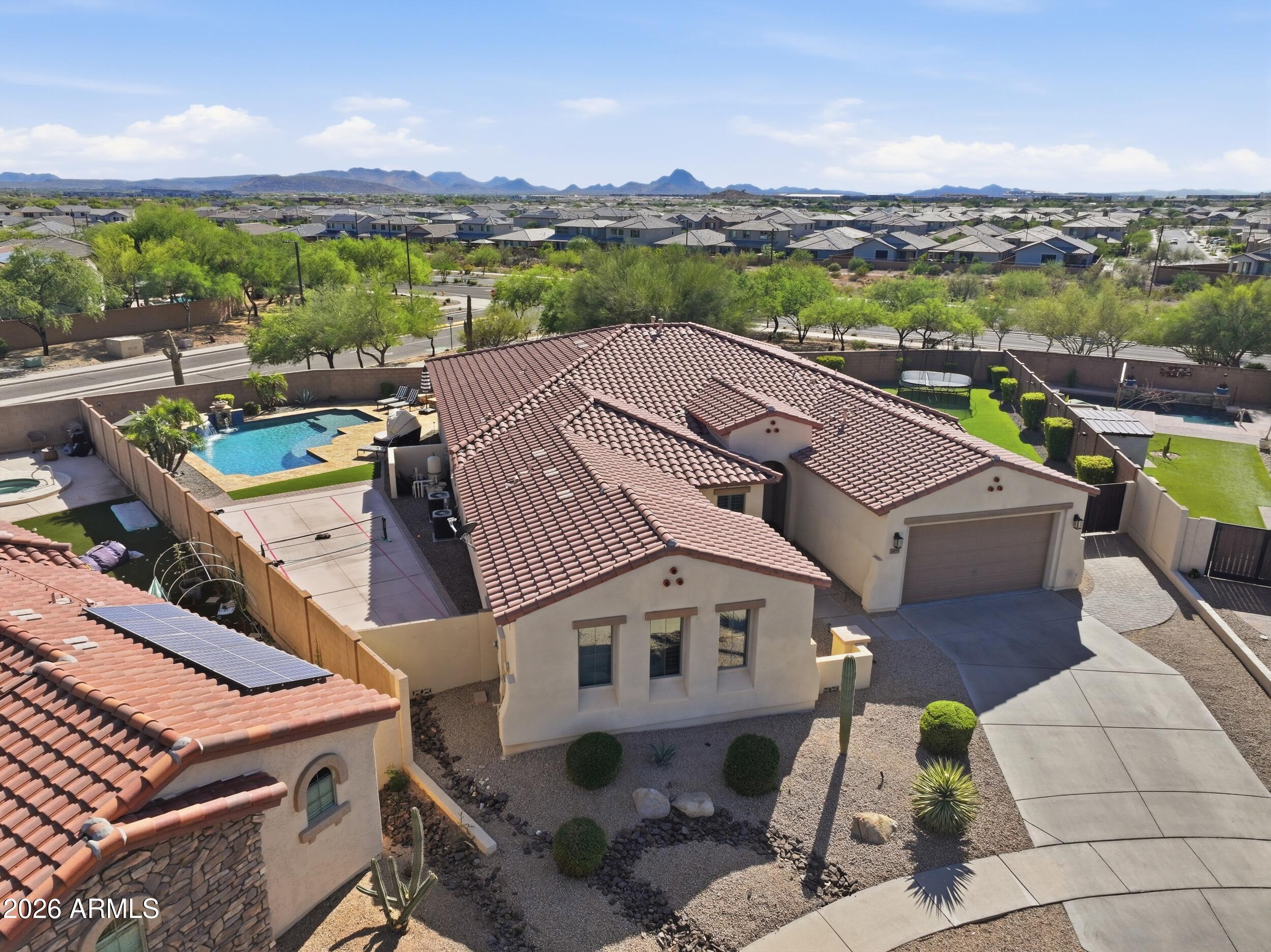 Tucked inside Sonoran Foothills, this completely upgraded home sits on a premium lot with no neighbors behind. Resort style backyard with pool, spa, travertine, pergola, firepit, turf, a pickleball court, an RV gate, and upgraded lighting, so you can enjoy your backyard anytime. Open layout with a beautifully upgraded kitchen featuring Sub Zero, gas range, and a large island flowing into the main living space. Split floor plan with a private primary suite on one side and a secondary oversized en suite on the other, offering a flexible guest or multi gen setup. Plus an additional office or den with its own exterior access. This home also has access to community amenities including a pool, clubhouse, tennis, and pickleball courts. This beautiful home and community do not disappoint!