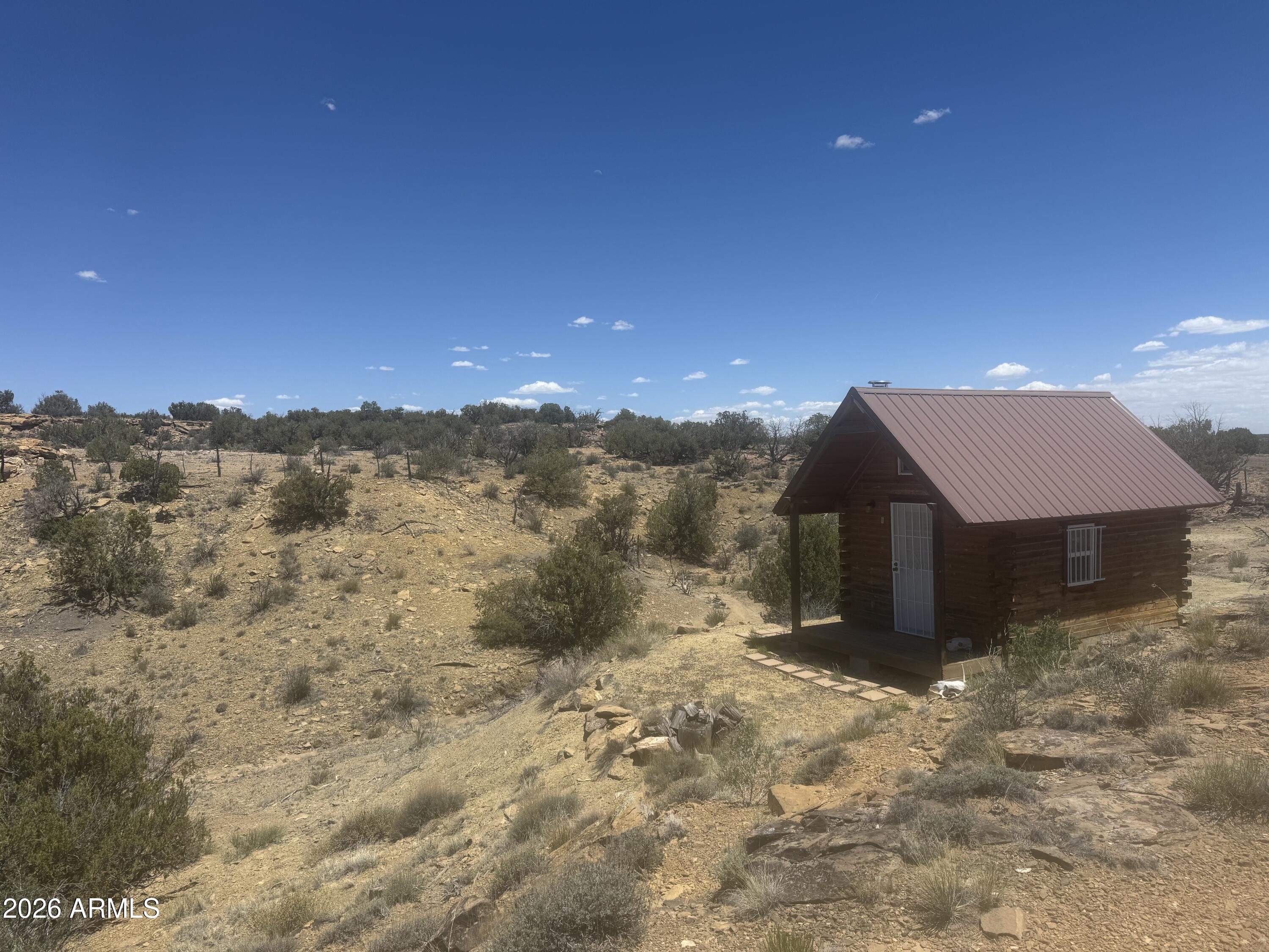 Out where Arizona brushes up against New Mexico, where the horizon stretches farther than your worries and the silence feels older than time itself, there's a hidden 36.56-acre off-grid escape waiting for the right kind of soul. Tucked inside a remote subdivision where the lots are large and the neighbors are few and far between, this rugged property offers the kind of privacy most people only dream about. Bordered by State Trust land on the west and north, with New Mexico stretching out beyond the eastern line, the views seem endless in every direction. Sitting quietly on the land is a tiny off-grid cabin with a loft -- simple, sturdy, and ready for someone who values independence over convenience. A perfect basecamp for the prepper, the recluse, the hunter, the stargazer, or the person who's simply done with noise, crowds, and city life. No traffic. No city lights. No nonsense. Ain't nobody around. Wake to glowing sunrises and spend nights under skies packed with stars. Bring your generator, your water tanks, your dreams of self-reliance, and your need for peace and quiet. Whether you want a hunting hideaway, an off-grid homestead, or a place to disappear from the modern world for a while, this property delivers room to breathe and solitude that's hard to find anymore. 36.56 acres with a tiny cabin and loft on the Arizona/New Mexico border, bordered by State Trust land on the west and north, offered at $35,000 cash. No seller financing offered. Some properties are investments. Some are adventures. This one is an escape story waiting to be written. 34°37'37.12" N  109°02'53.36"W