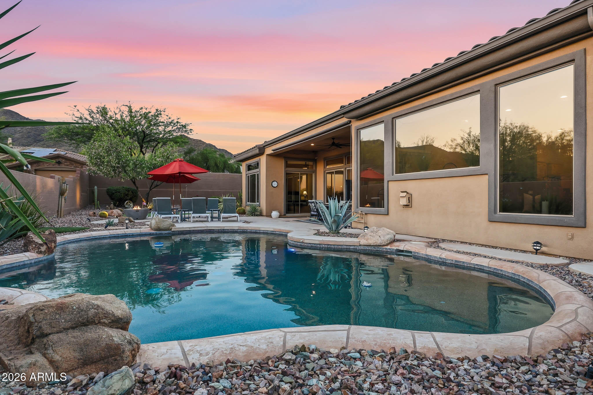 Experience the luxury of Anthem Country Club in this stunning single-story re-imagined floor plan featuring 4 bedrooms and 3.5 baths, including three bedrooms with private en-suites. The expansive living area is an entertainer's dream, boasting a custom wet bar with a beer tap and wine racks. A gourmet kitchen with double ovens and a large island that flows into a family room anchored by a gas fireplace. The massive primary suite offers a sitting area and spa-like bath with a separate tub. Step outside to a west-facing backyard oasis designed to capture breathtaking mountain views and vibrant Arizona sunsets. This resort-style retreat features a heated pool, built-in BBQ, synthetic putting green, and lush landscaping, offering the ultimate vacation lifestyle in a premier gated community.