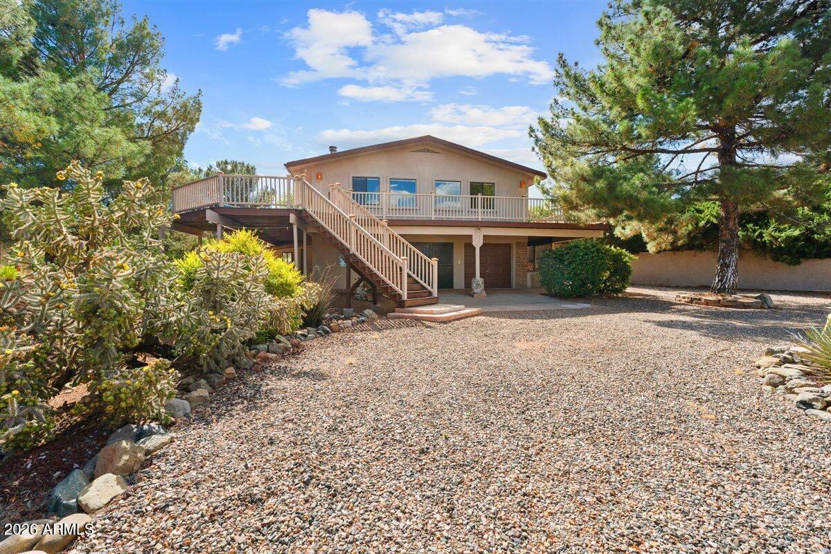 Tucked away on a landscaped ¾-acre corner lot in the heart of Cottonwood this beautifully quaint 3 bed, 2 bath home offers privacy, views, and flexibility. Ideal layout features 2 bedrooms upstairs plus a private lower-level suite with separate entrance--perfect for guests, multi-generational living, or rental potential. Enjoy Red Rock views from the upper deck, peaceful retreat spaces, a bridge over the wash, fire pit, and hot tub. The level lot offers ample parking, RV space, room to expand, and a private well. Recent upgrades include new windows, remodeled interiors, updated kitchen with Samsung smart appliances, water softener, R/O system, irrigation, and new lighting throughout. Located just minutes from Cottonwood's revitalized downtown, wineries and restaurants. This is one that you absolutely do not want to miss!  Currently, one of the garages has been converted into a man cave but can easily be taken back to a useable garage.  There is also a 3rd garage for motorcycles or ATVs on property as well.  This property offers so many options!  There is also a .33ac lot adjacent to the home that is offered for sale as well.