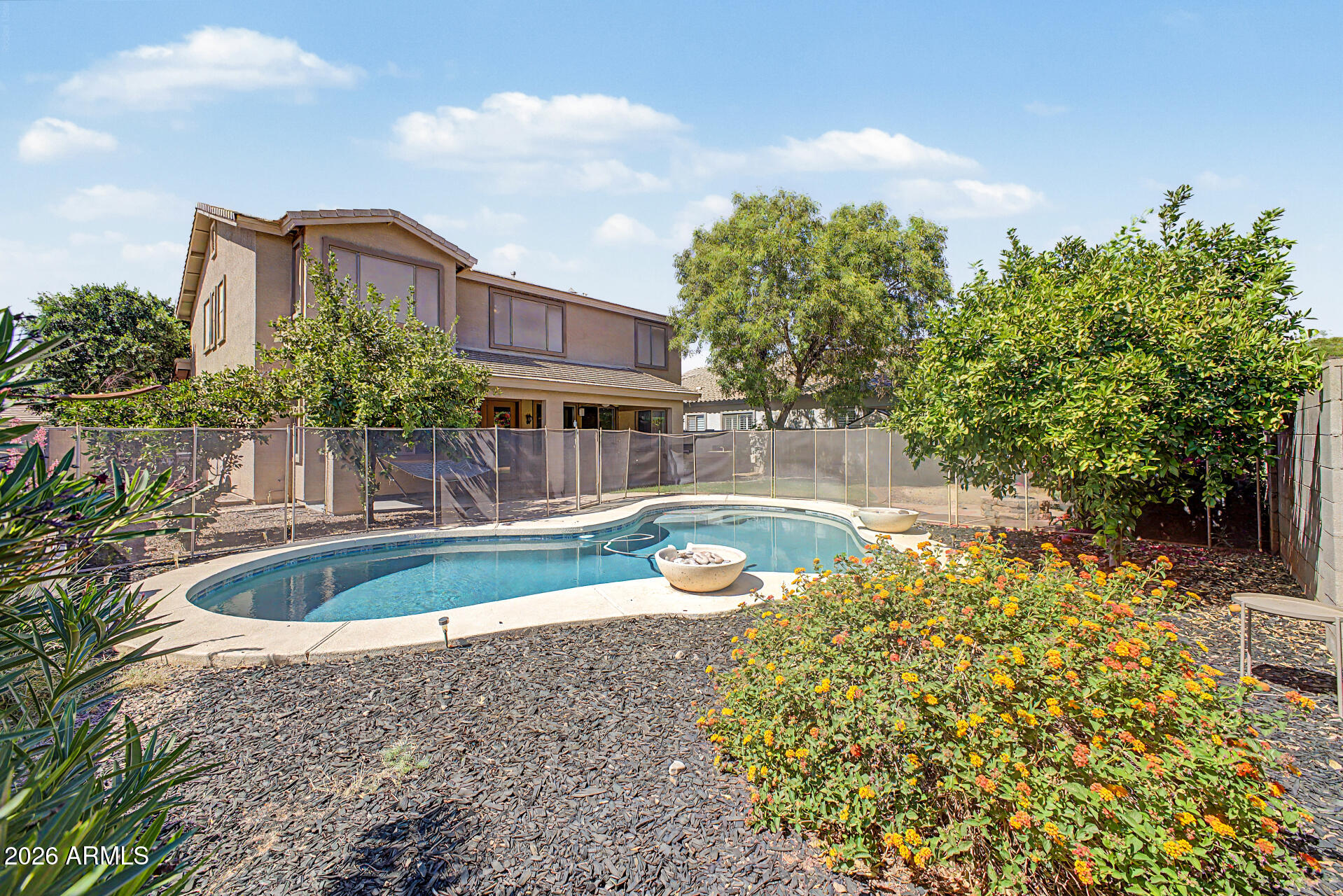 Spacious and beautifully upgraded 6-bedroom, 3.5-bath home featuring a true resort-style backyard designed for entertaining. The gourmet kitchen showcases custom alder wood cabinetry with pull-out drawers and abundant storage, granite countertops, stainless steel appliances, double ovens, crown molding, and a large pantry. The breakfast nook overlooks the sparkling play pool with dual water features. The open family room offers surround sound and a ceiling fan for added comfort. Upstairs features a versatile loft with a professionally designed office/workstation area and generously sized bedrooms throughout. Step outside to your private backyard retreat with an extended covered patio, built-in BBQ, sink, and additional storage. A fantastic home for entertaining and everyday living.