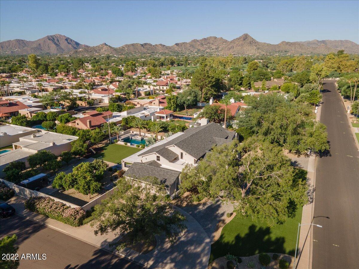 Welcome to one of the Valley's most sought after communities, hidden between Paradise Valley & Scottsdale. It's a hidden oasis with tree lined streets, large grassy lots, and where the neighbors are all about ''Community''.
This home has a split floor plan featuring 4 bedrooms, 3 full and 2 half baths, and is the epitome of charm and sophistication. Reimagined in 2016, you will notice all of today's finishes that a luxury buyer is looking for!   With a grand living room, spacious dining room, and gourmet kitchen, this home is perfect for entertaining! Natural light fills every room! The guest-wing offers privacy as it has a generous size En-suite bedroom with full bathroom,  and 2 more additional bedrooms that share a full bath,  each with their own en-suite vanities. The artist loft has hardwood floors, an additional office,  and powder room giving you all the flexibility an active family needs. The spacious primary suite offers a gas fireplace with its own ensuite- office/ fitness room and a fabulous master bathroom, including a walk-in shower, dual vanities, make-up vanity and generous size closet with LED lighting and custom built-ins. The resort style backyard features a lush entertainer's paradise, with 24 types of mature citrus trees,  a heated swimming pool, a gas fireplace, a fire pit, built-in BBQ, and a sport court that is large enough for pickle ball! The home is situated perfectly on a 35,000+ sq.ft.  lot with North/South Exposure, a side entry RV Gate for your toys, and a 3 car side entry garage.  Home has been meticulously and lovingly maintained by the homeowners.