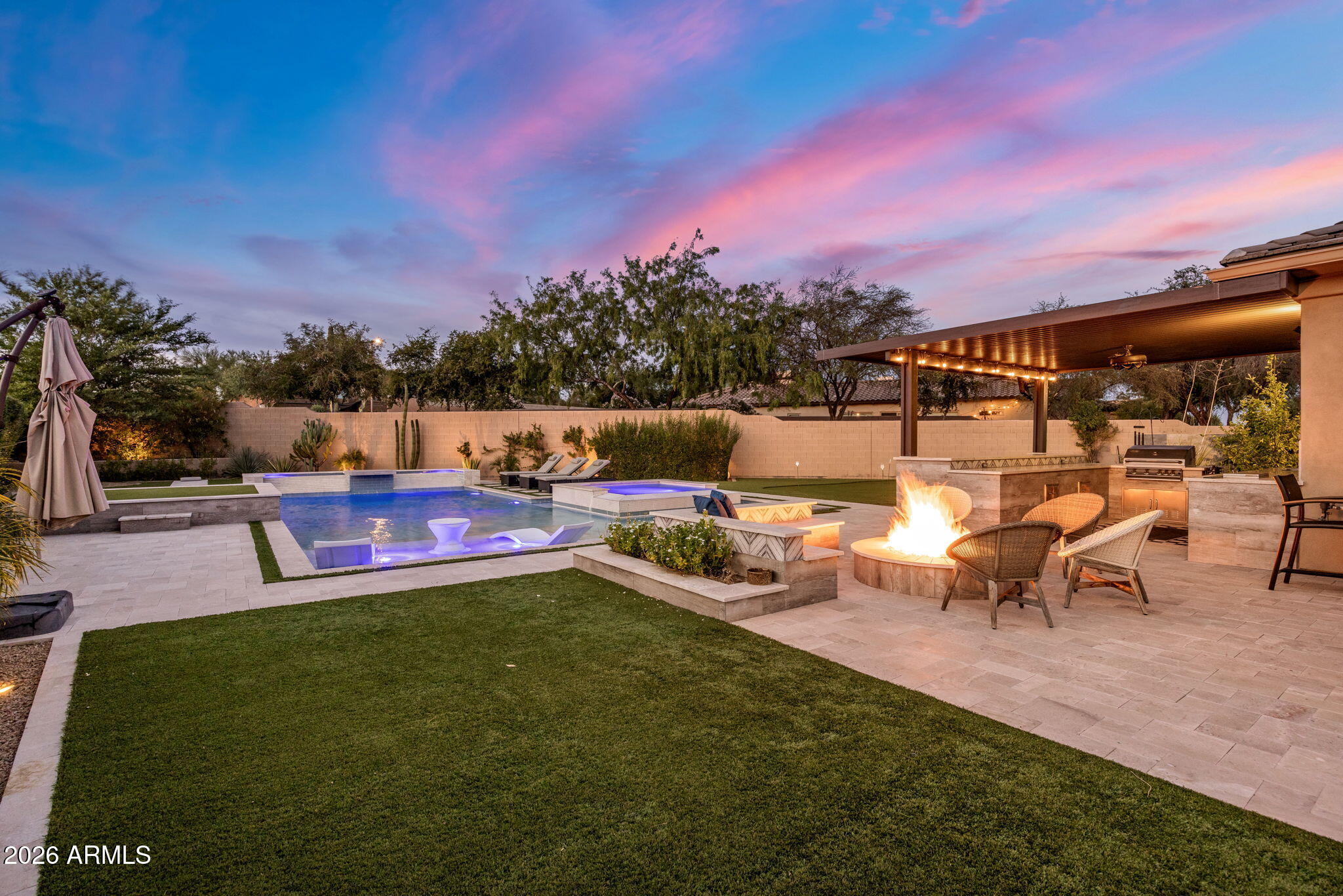 Fully Remodeled Luxury Estate in Award-Winning Aviano at Desert Ridge | Basement | Main-Level Guest Retreat | Resort Backyard
Set on a premium corner lot backing to a natural wash, this extraordinary residence offers one of Aviano at Desert Ridge's most coveted floor plans--combining a finished basement, main-level secondary primary suite, extensive renovations, and an exceptional resort-style outdoor experience. Thoughtfully reimagined with a level of design rarely found in the neighborhood, this 6-bedroom, 4.5-bath luxury home blends elevated finishes with effortless functionality. Every detail was curated to create a truly semi-custom feel, including bathrooms completely remodeled in 2026 and refined upgrades throughout. At the heart of the home is a completely redesigned chef's kitche unlike anything else currently offered in Aviano. Created as a statement space for both entertaining and daily living, the kitchen features an oversized quartz island, custom cabinetry, designer floating shelving, freestanding range, built-in refrigerator, integrated Miele espresso station, and a level of finish and craftsmanship that sets this home apart.
The flexible floor plan includes a main-level secondary primary suite ideal for guests or multigenerational living. Downstairs, the finished basement expands the home with two additional bedrooms, a full bathroom, and a spacious family/media room creating endless possibilities for entertaining, recreation, or private guest accommodations.
Designed to rival a private resort, the backyard showcases a custom pool with expansive Baja shelf, oversized spa, swim-up bar, elevated golf tee box, multiple putting greens, outdoor kitchen, custom fire feature, covered entertaining spaces, lush turf, and mature landscaping framed by wash views and unforgettable Arizona sunsets.
Located within the award-winning community of Aviano at Desert Ridge, residents enjoy exceptional amenities including a heated resort pool and spa, full cardio and weight-training fitness center, tennis courts, pickleball courts, basketball courts, parks throughout the community, scenic walking paths, and year-round lifestyle programming--all minutes from Desert Ridge Marketplace, High Street, Scottsdale Quarter, Kierland Commons, and major freeway access.
A rare opportunity to own one of Desert Ridge's most distinctive luxury homes.