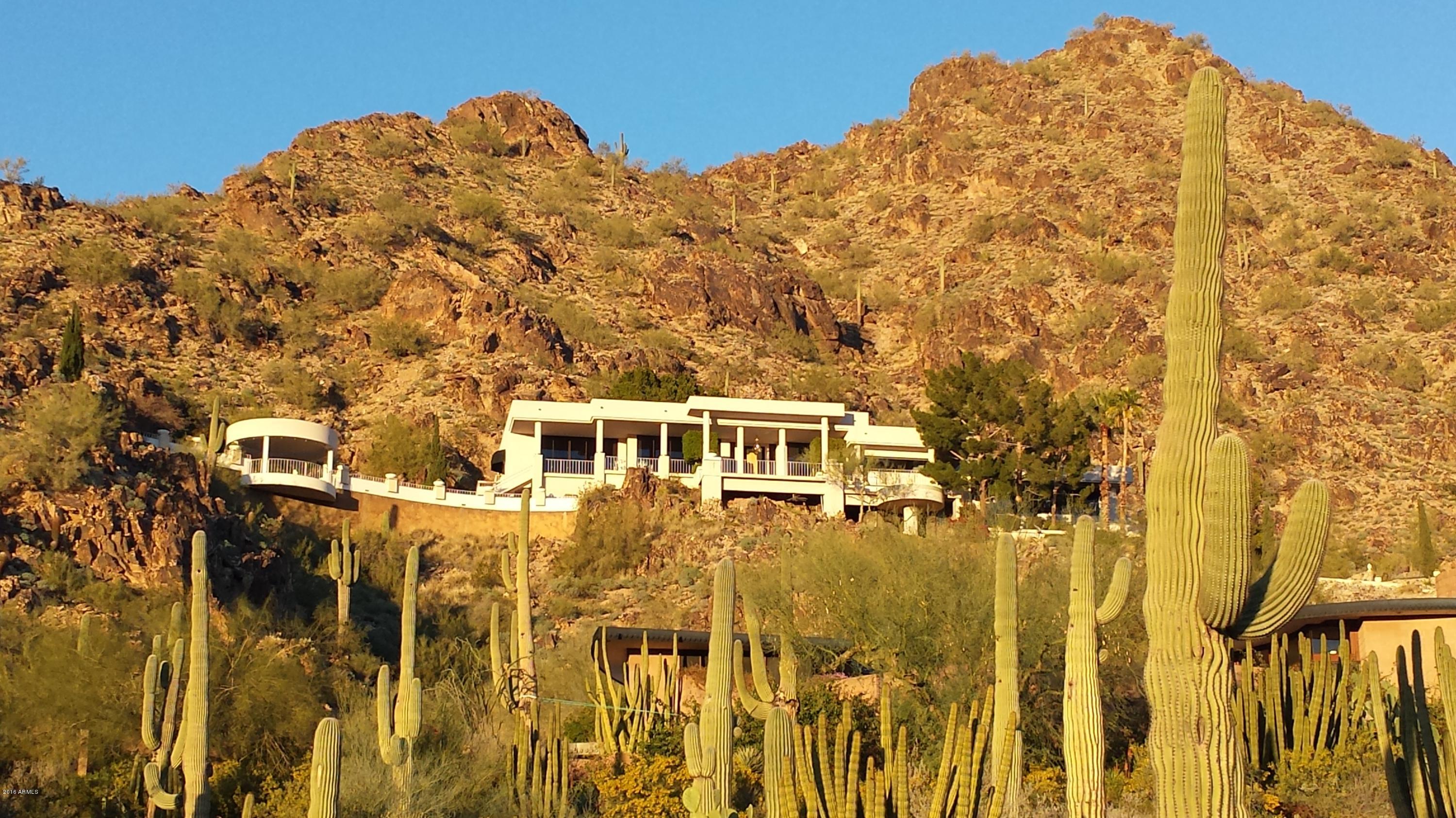 Sitting on 10.35 acres, this beauty is situated higher than any house on the southwest end of Mummy Mountain facing both the Praying Monk on Camelback Mtn and downtown Phoenix. Nestled over the historic Camelback Resort & Paradise
Valley Country Club, this is the ultimate in privacy with the property stretching to the top of the 2,260 ft high mountain while bordering the Mummy Mountain Preserve Trust on multiple sides. In addition to 6,867 sq/ft of living space, this property includes TWO (9 acre & 1 acre) lots.
The views are dynamic and the they are prevalent from most all the rooms.