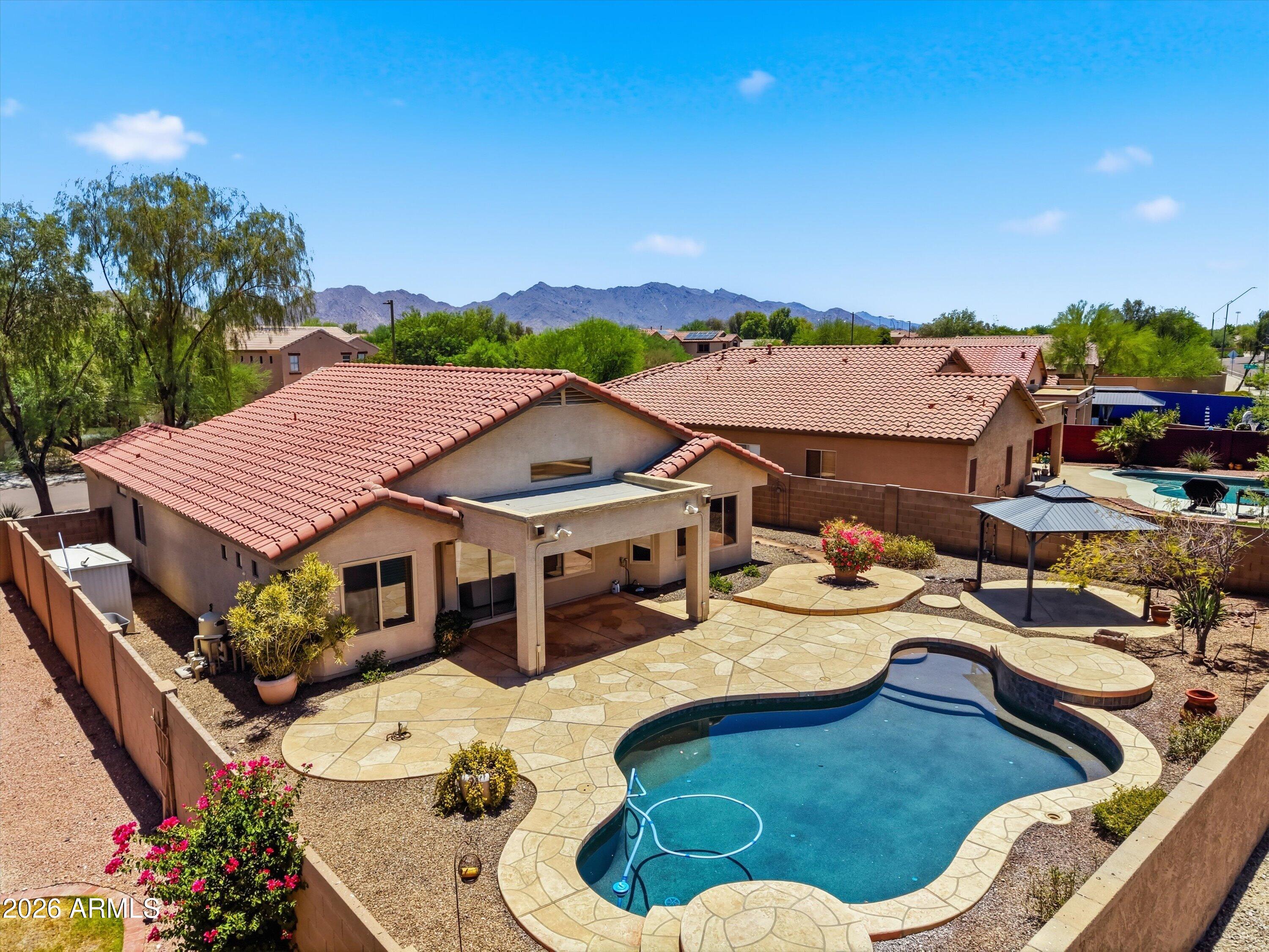 Welcome to this beautifully upgraded 3-bed, 2-bath home in highly desirable Estrella Mountain. Enjoy AZ living with a backyard retreat featuring a sparkling pool with water features and a beautiful gazebo. Inside is a remodeled kitchen with updated finishes, countertops and new dishwasher and microwave. High-end lighting and fixtures can be seen throughout the home. The remodeled primary bath offers a stylish and relaxing space to unwind. Other major system updates provide peace of mind, including newer AC unit (3 years), new water heater, and new garage door. The laundry room is equipped with additional cabinetry for storage and organization. Conveniently located near community amenities, parks, trails, and schools. This home offers the perfect combination of comfort, style, and value!