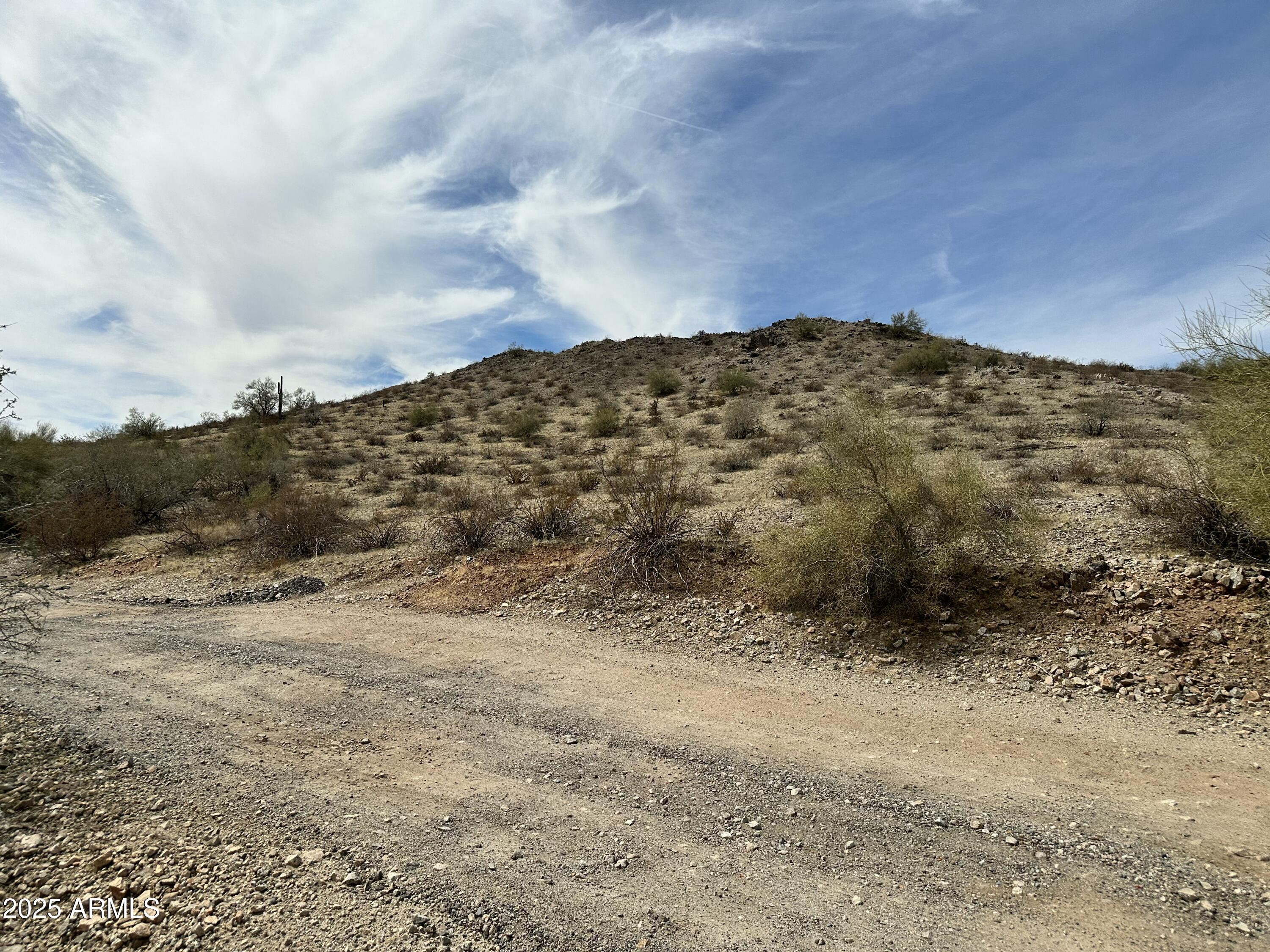 This spacious lot, nestled at the base of the majestic Estrella Mountains, presents breathtaking views of the downtown skyline. Imagine waking up to panoramic vistas and being just minutes away from Phoenix International Raceway and an array of hiking, biking, and horse riding trails, allowing for endless outdoor adventures. Golf enthusiasts will have access to nearby world-class golf courses. For those seeking tranquility, the nearby Estrella Mountain Park provides a serene escape, perfect for relaxation and recreation. Whether you're seeking a great investment or envisioning the construction of your dream home, this lot presents an exceptional opportunity. Use GPS coordinates: 33.3685585619843, -112.354235594721
