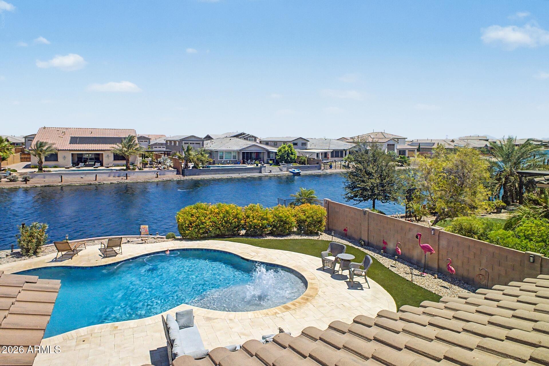 Wake up to peaceful lake views and end your day with sunsets reflected across the water in this exceptional lakeside pool home. Offering a rare combination of privacy, space, and resort-style living, this property is designed for those who appreciate both relaxation and entertaining. The thoughtfully designed floor plan provides room for everyone, featuring a downstairs bedroom and full bathroom that offers flexibility for guests or a private retreat. Upstairs, a generous loft creates the perfect bonus space -- whether you imagine a media room, game area, workspace, or a quiet place to unwind. The heart of the home flows effortlessly into the outdoor living spaces, where the sparkling pool and lake backdrop create the ultimate setting for gatherings, weekend lounging, or simply enjoying enjoying the Arizona lifestyle. 
The views are truly the feature you'll find yourself coming back to again and again.

Recent updates, including fresh interior paint and new carpet, add a clean and refreshed feel, while the 3-car tandem garage provides extra space for vehicles, storage, or hobbies.

With a location that offers everyday tranquility and a home built for making memories, this lakeside retreat delivers the lifestyle you've been waiting for.