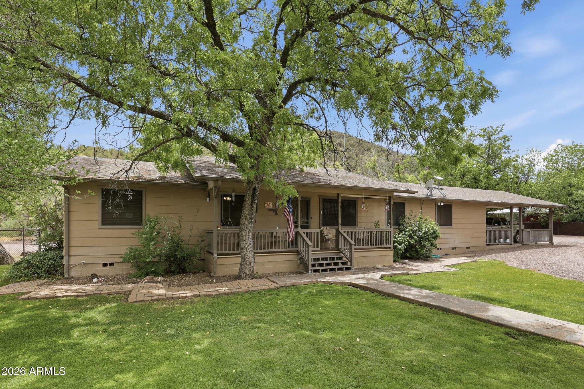 Suburban Ranch Living Close to Payson! 3.20 (+-) acre lot backs to, Gibson Wash and Tonto National Forest, has a 1,500(+-). sq.' steel double RV Garage that has 2, 12(+-) foot roll up doors with a great work bench, storage room with loft and there's NO HOA fees! The 2,276 sq.' single level home has a park like setting with beautiful mountain and forest views from the screened porch off the family room, the front and back covered porches and rear large open deck. The Family room has a propane stove, vaulted ceilings, large windows and knotty pine rustic accents. The kitchen is well appointed with a skylight, granite counter tops, spacious pantry, oven/micro and a breakfast bar. The split floorplan has a spacious primary suite with a propane FP, large walk-in closet and the en-suite bath... has a dual vanity, skylights and step-in shower. Across the way there's a den/office and 2 bedrooms with guest bath and linen closet. The rear sun room entrance gives you easy access from the back yard and 2+-car carport to the laundry room, kitchen and family room. The 2+ car carport would make a great location for a large family or neighborhood gathering. Another 2-car garage is well equipped with cabinets and lots of counter space for your tools/hobbies and there's a separate walk-in storage area to store your treasures. This garage also has an upstairs loft with a separate entrance that gives you additional storage and has lots of possibilities. The property is fenced and cross fenced and has a huge fenced dog run and 2 covered chain link fence kennels with water and electric. There's plenty of room for your horses, chickens, and livestock and the rear lot may be a good pasture area. There are approx. 30 walnut trees and a nice variety of well-established fruit trees and lots of room for your garden with a separate private well for easy watering. Tonto National Forest has lots of trails for hiking, mountain biking, riding horses and quads.