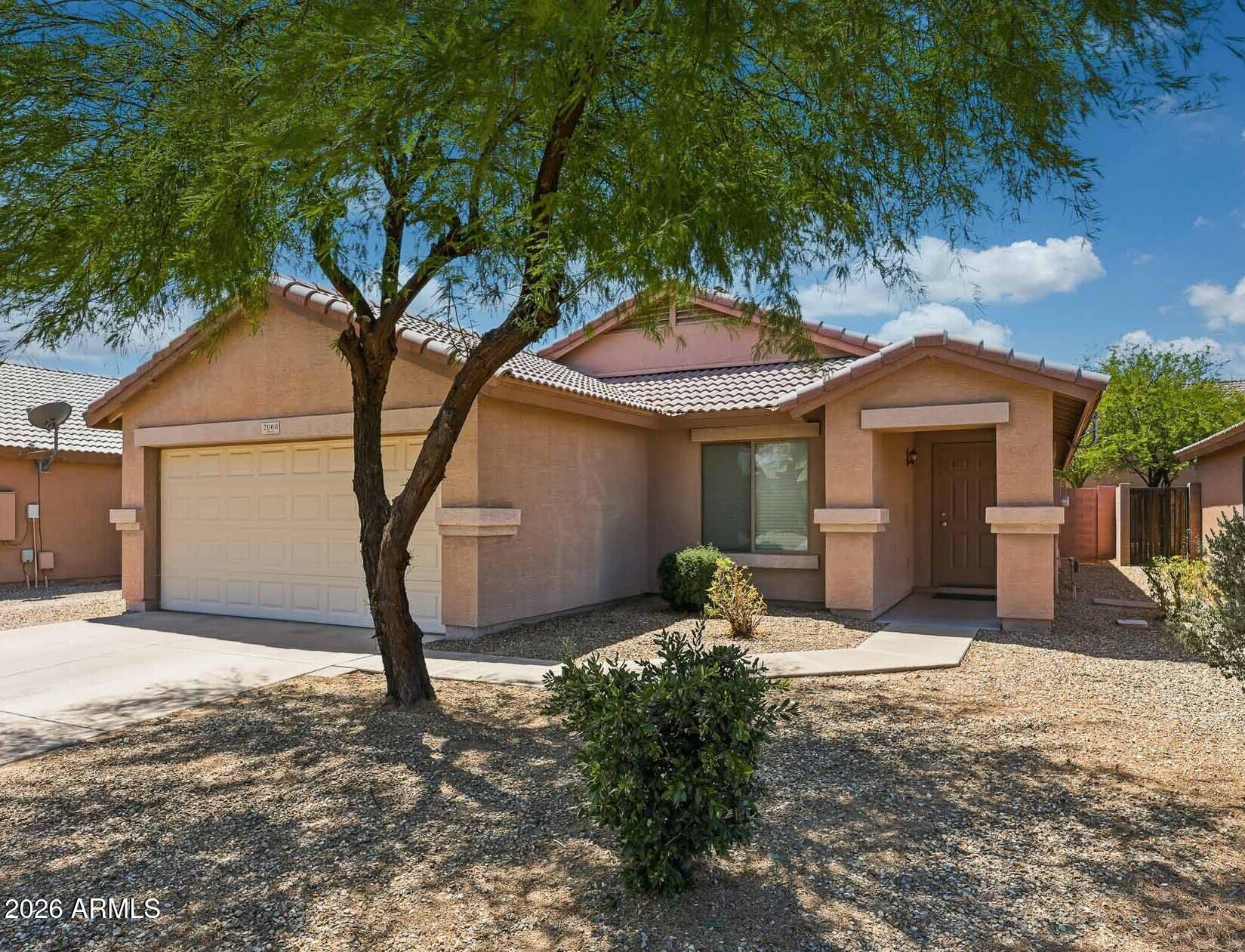 Location meets easy living just minutes from Goodyear Ballpark, shopping, dining, and everyday conveniences. This inviting 3-bedroom + den, 2-bath home offers a desirable split floor plan with vaulted ceilings and low-maintenance tile flooring in all the right places. The kitchen blends function and flow with ample cabinetry and stainless steel appliances (refrigerator included), plus washer and dryer included. The spacious primary suite serves as a private retreat with a large closet and ensuite bath. Secondary bedrooms are thoughtfully split for added privacy, while the den provides flexible space for an office,  or additional living area. Step outside to a low-maintenance backyard designed for easy upkeep. Bonus: RV gate with large side yard storage.