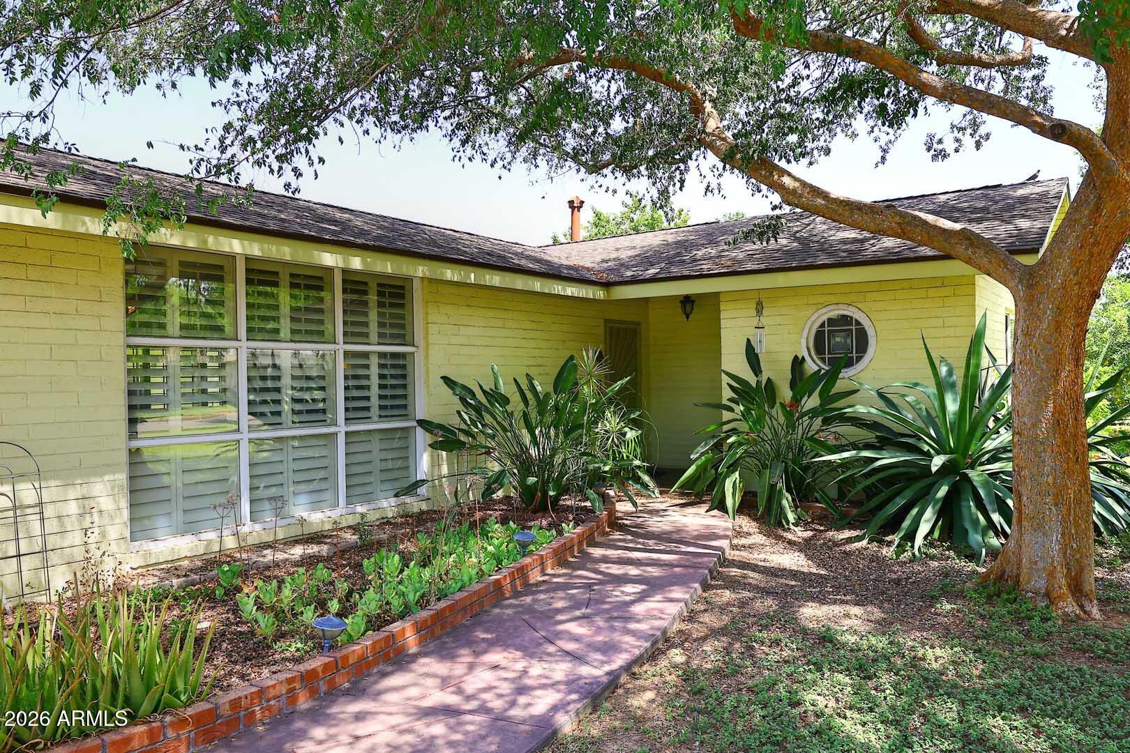 North Central Phoenix Gem on a Tree-Lined Street! This 4-BR, 3-BA home on a 14,000 SF irrigated lot w/mature landscaping ,sparkling pool,OWNED SOLAR.Spacious living areas and a versatile floor plan offer comfortable  living and entertaining. A rare feature is the two 2-car garages: an attached garage plus a detached garage built in 2010 with 2x6 framing, its own 100-amp sub-panel, and sewer and water connections already in place. Original construction drawings are available, providing valuable information for a potential casita, guest house, home office, or studio conversion (subject to city approval). Located in the Royal Palm Park neighborhood, this property combines classic charm, generous outdoor space, and exceptional future potential. Welcome!!