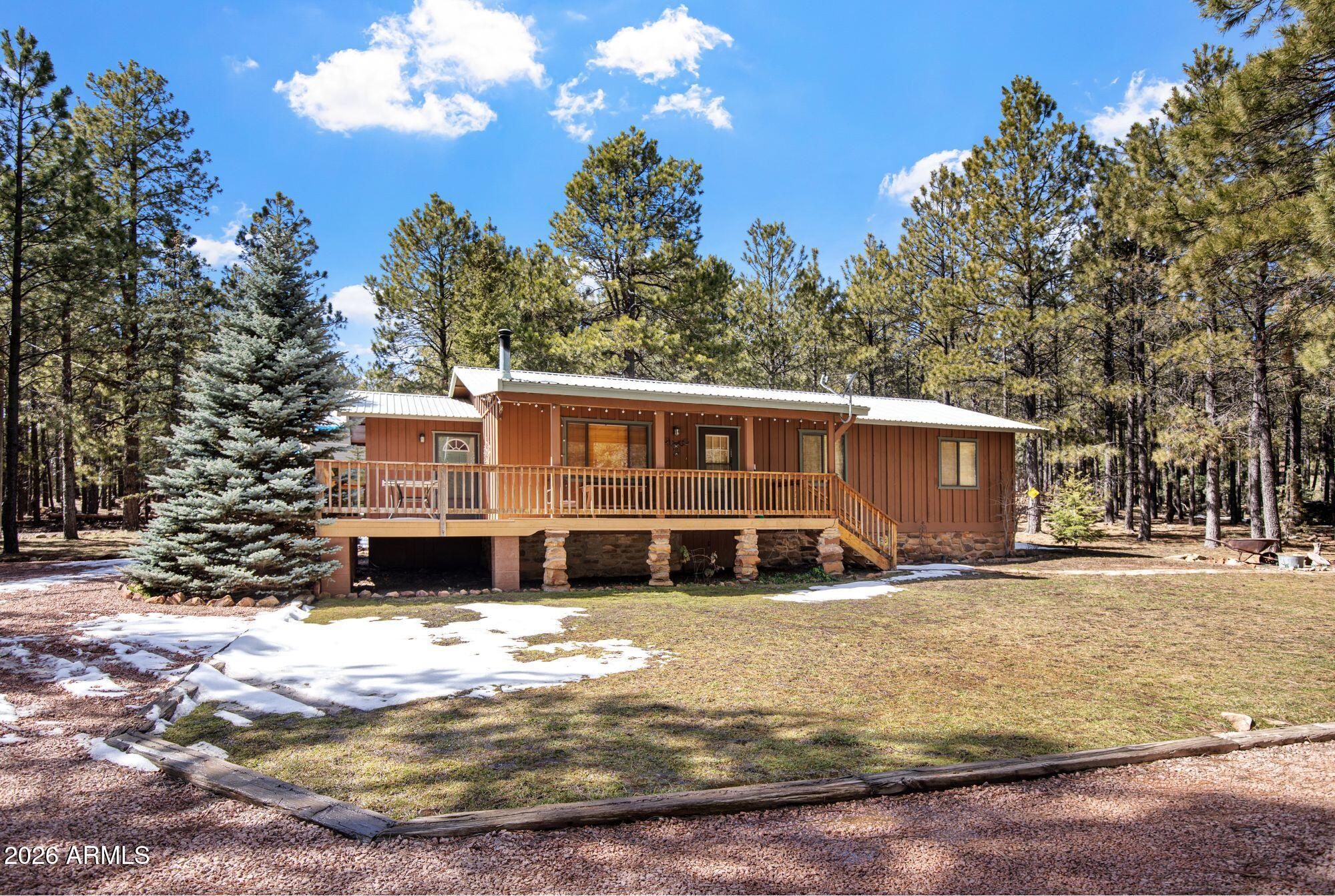 Welcome to your perfect tall-pines retreat in Forest Lakes -- a beautifully updated 3 Bed / 2 Bath cabin that is truly move-in ready and designed for easy, relaxed mountain living.

Set on a coveted south-side corner lot (with fewer homes and added privacy), this lovingly maintained cabin offers thoughtful upgrades and a layout that simply works. The property features a 3-way entry driveway with pull-through access, making camper or trailer storage simple and stress-free. The large detached garage provides plenty of room for your forest toys -- ATVs, kayaks, bikes, and all the gear that comes with cabin life.

The spacious front porch is made for slowing down. Morning coffee in the cool mountain air, summer dinners with friends, or quiet evenings listening to the breeze through the... ... pines, this is where memories are made.

Inside, the home offers an open-concept layout where the kitchen, dining, and family room all flow together comfortably in one welcoming space. The newly remodeled kitchen is perfect for gathering -- imagine the kids lined up at the island for weekend pancakes while you cook in your beautifully updated kitchen. From here, you can easily watch the family in the living area or keep an eye on the kids heading in and out to the porch.

The family room is warm and inviting, anchored by an adorable freestanding wood-burning stove and offering another easy access point to the porch -- ideal for entertaining, hosting holidays, or simply cozying up after a day outdoors. Rustic wood walls add authentic cabin charm while maintaining a clean, refreshed feel throughout.

The owner's bedroom suite is a rare and special feature for the area. Generously sized, it includes dual "his and hers" closets and its own private bathroom -- something not commonly found in Forest Lakes. The en-suite bath has been newly remodeled with a beautiful walk-in shower and a convenient laundry/storage area. Two additional bedrooms share a separate guest bath with a tub/shower combo, offering comfort and convenience for family and visitors.

Major updates have already been completed, including a tankless water heater, so you can enjoy modern efficiency with mountain charm. The home is being offered mostly furnished (a detailed list will be provided), making your transition into cabin life simple and seamless.

Beyond the home itself, the lifestyle is what truly sets this property apart. Just a two hour scenic drive from Phoenix, you can revel in the world's best summer weather with average temps in the mid 70's and a true 4 season climate to enjoy year round. Forest Lakes is surrounded by towering pines, scenic hiking trails, nearby streams, peaceful lakes for fishing, and abundant wildlife.

The community is welcoming and close-knit, hosting frequent family-friendly social events throughout the summer -- adding to the true vacation feel of the area.

If you've been dreaming of a well-cared-for cabin where everything has been thoughtfully updated and meticulously maintained -- a place where you can simply unpack and start living -- this Forest Lakes retreat delivers the relaxing mountain lifestyle you've been waiting for.
