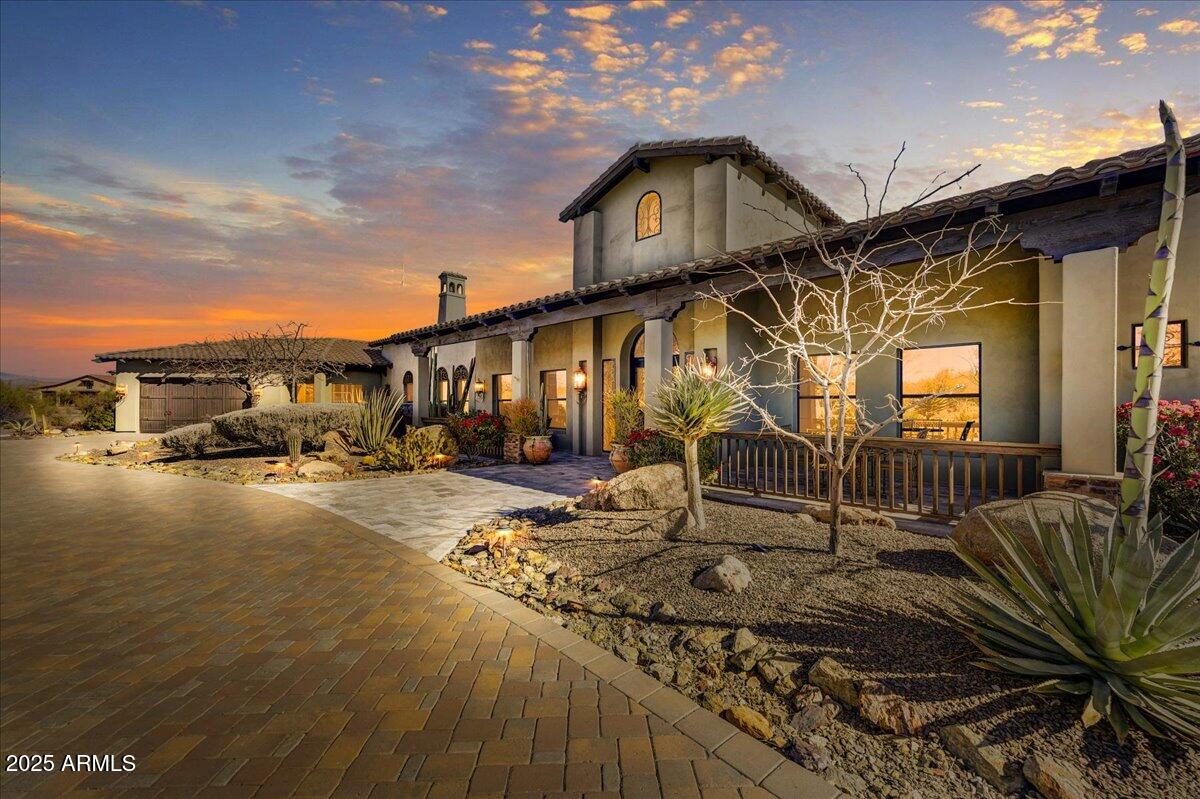 Whether a desire for a luxurious custom-built home that offers privacy, incredible views and a tranquil environment, or a place to entertain on a grand scale, or a beautiful property for horses or to showcase your car collection, this home offers all this and more. 

Situated on 3.42 acres in the luxury gated community of Granite Mountain Ranch in North Scottsdale, this home projects a timelessness with its European and Spanish influences.  Subtle yet impressive details emphasize the quality of craftmanship throughout. 

From the moment you enter the home, you will be captivated.   Creating drama and defining the character of the home is an entry hall and formal dining room accented by a 26' high ceiling accentuated with massive trestle wood beams separated with tongue and groove wood planks.  Walls of glass and doors opening to the gardens create the perfect atmosphere for entertaining large groups of family and friends.

The kitchen will be a joy to work in with top-of-the-line appliances like Wolf and Subzero and Bosch, a large walk-in pantry, a Butler's pantry and a gas-burning fireplace.   With views of the mountains to the east and the garden and pool, the casual dining area is the perfect place to begin the day.  Watch the sun rise, painting the sky bright, vivid colors, while enjoying your first cup of coffee.

The spacious great room with its entertainment bar and massive fireplace has direct access through its 20-foot disappearing wall of glass to a resort style backyard, taking entertaining to a whole new level.  Designed so that one could enjoy all of Arizona's natural beauty year-round, highlights include a deeply covered patio with a stone faced, gas burning fireplace, an outdoor ramada with a Napolean Gas Grill, a pizza oven and a sit-down bar.  Above the ramada is a viewing deck offering an even more impressive 360 view of the surrounding mountains that include Troon Mountain, Pinnacle Peak, the landmark Four Peaks, and the Mazatzal, McDowell and Continental Mountain ranges.  An oversized heated pool with a large Baha deck, a raised spa with a spillover water feature, a muti-point putting green and a chipping green for the golf enthusiast, and winding pathways through gardens of native desert plants and a variety of citrus trees create the perfect outdoor lifestyle.
  
Bedrooms in the home are all oversized with the large primary suite also offering direct access to the pool and outdoor areas.  It is highlighted with a gas burning fireplace, a built-in beverage bar, a sumptuous bathroom with its free-standing tub, double sinks, separate walk-in shower, a laundry area with a stackable washer and dryer, and an oversized closet space.
 
Follow the outdoor winding pathways, lush with vegetation and a variety of citrus trees, to the casita.  Whether for friends and family visiting or live-in help, this two-bedroom ensuite guest house offers a full kitchen, laundry room, a dining space with a conversation area in front of a fireplace and a living room.  Front and back courtyards allow for both privacy and enjoyment of the surrounding mountain views.

Granite Mountain Ranch, the only gated equestrian community in Scottsdale, is in the Rio Verde Foothills of North Scottsdale, adjacent to the Tonto National Forest. There are 100 home sites on 313 acres, paved roads, and a 15-acre equestrian common area with riding arenas, round pens, and wash stalls.

While there currently are no private horse facilities on this property, should you wish, and with ARC approval, there is plenty of room for a barn and paddock.
 
Residents choose Granite Mountain Ranch for the tranquility the area offers, the incredible views and its close proximity to miles of McDowell Sonoran Preserve trails for horseback riding, biking and hiking. Granite Mountain Ranch is also adjacent to the 2.5-million-acre Tonto National Forest, allowing easy access for trail riding and ATV use. Only 10 minutes to incredible kayaking on the Rio Verde River. Nearby lakes offer fishing and boating opportunities. Also in the area are world class trainers for "cutting," "dressage," and "roping."  Just a very short distance away will be the new "Shops at Rio Verde," a 16.80-acre site with plans for retail, restaurants, medical and other mixed use spaces. 

Within a 10 to 30 minute drive are many of Arizona's top golf courses, such as Golf Club of Scottsdale, Troon North, or Troon Country Club, Estancia and The Boulders, as well as many wonderful casual and fine dining restaurants, all types of shopping, area schools and hospitals, including the Mayo Clinic.