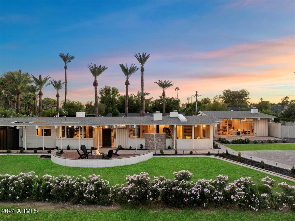 Welcome to a rare mid-century modern retreat on a huge 36,440 sq. ft. lot updated to todays standards. This 4,305-square-foot main house, plus an additional 904-square-foot guest house, offers four bedrooms and 4.5 baths in the main home, brand new roof and high-efficiency AC units, both with a 10-year warranty. The open layout, floor-to-ceiling glass walls, and iconic architectural lines draw in natural light and frame stunning views of entire Camelback Mountain. The guest house is equipped with a full bath, kitchenette, and private entrance.  The expansive backyard is ready for gatherings, with a bocce ball court, sand volleyball court, peaceful pavilion and firepit. Original Architecture done by George Kenneth Rubel.