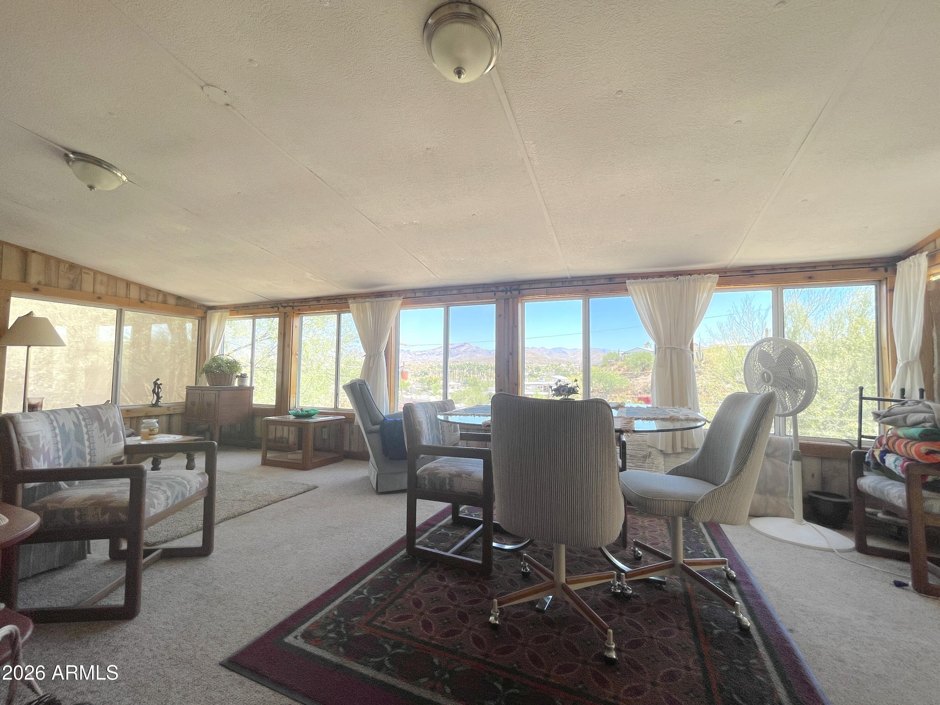 Discover a move-in ready desert retreat that checks all the boxes--perfect as a full-time residence, winter getaway, or investment opportunity. This furnished, 2 bedroom, 2 bath turnkey home offers stunning mountain views, privacy, and versatile indoor-outdoor living.
Enjoy panoramic views from the Arizona room step outside to unwind on the back patio--ideal for entertaining. The property features ample parking, including a spacious garage with storage room, plus two bonus storage sheds/workshops--perfect for hobbies, tools, or extra space. The covered carport adds flexibility for additional parking or shaded outdoor seating. Enjoy your own mature fruit trees in a low-maintenance landscape. Inside, this well-maintained home has a cozy pellet stove, updated kitchen, and room for guests.