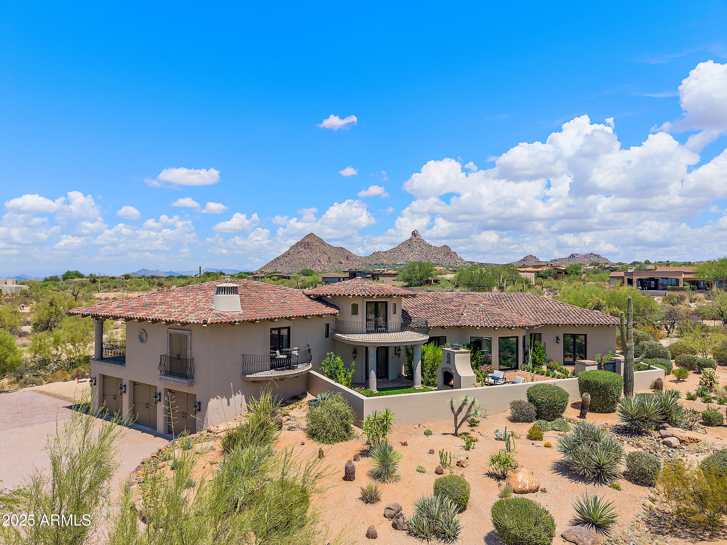 Discover the perfect blend of luxury and privacy in this 2.4 ac estate nestled in prestigious Sonoran Highlands. Behind a gated courtyard, a 2-sided fireplace and lush garden set a warm welcome. Step into the grand living room, where a limestone fireplace, vaulted wood ceilings, wide plank floors, and a telescoping glass wall seamlessly connect the indoors to a resort-style backyard oasis. The dining room features elegant herringbone wood flooring, coffered brick ceiling, and wine refrigerators. The kitchen is a masterpiece of design and functionality, outfitted with quartzite countertops, premium appliances, custom cabinetry, and a dumbwaiter for ultimate convenience. A rotunda with garden access and a staircase leads to a scenic balcony. The primary suite is a private retreat with a...