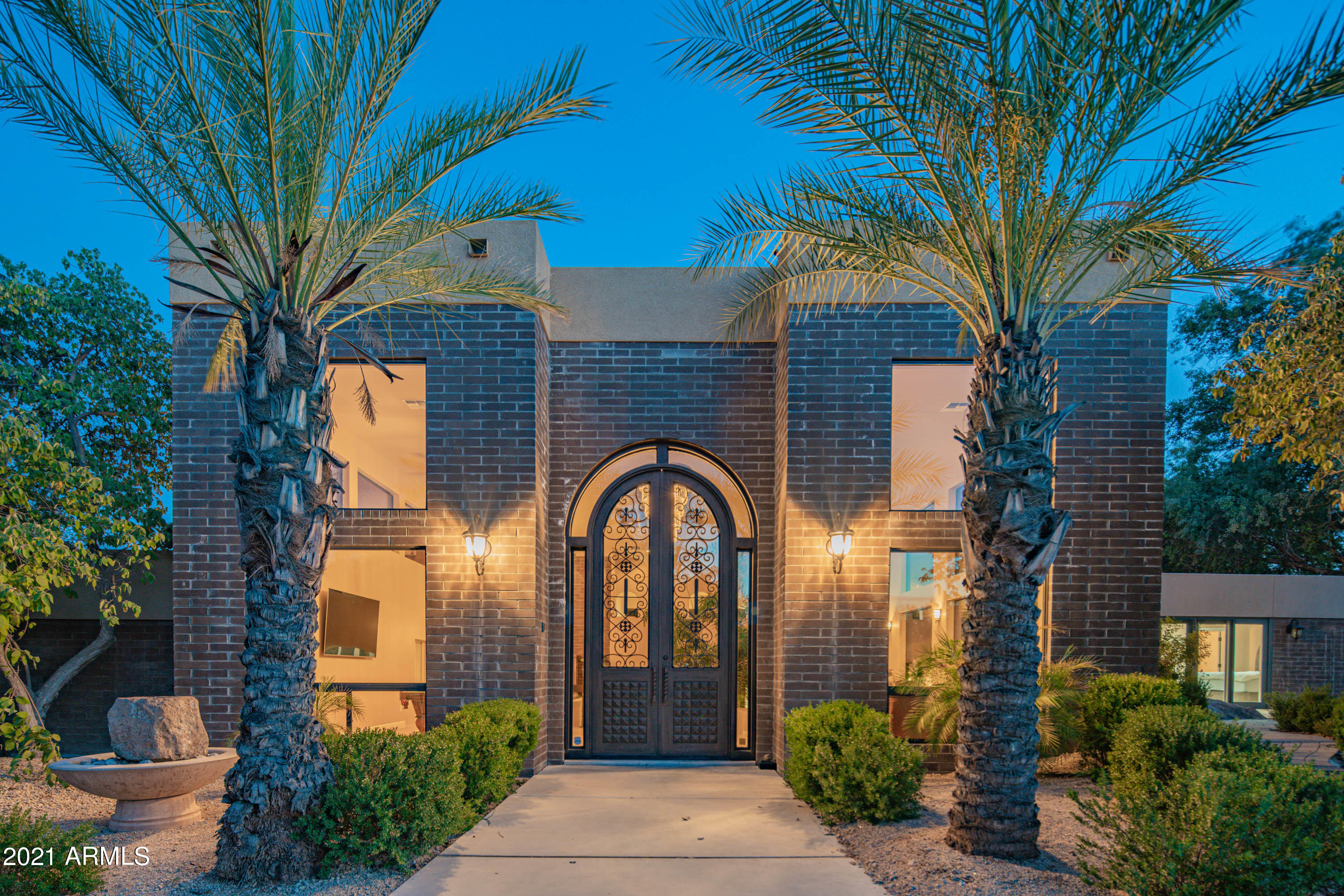 Priced to sell! Private gated resort in the Town of Paradise Valley on a 2.33-acre flat lot with surrounding mountain views.  Enjoy swimming, playing on your own private par 3 golf course, playing tennis, and biking in the rear yard on your own pavered path. This Frank LLoyd Wright inspired property has an all brick contemporary main house and a guest house totaling 8,508 square feet per county records. The original house was built in 1981 and expanded with an additional three bedrooms in 1990's. The current owner has completed in excess of $1.3M in house and landscape improvements between 2013 to 2017, including $400K in an addition of a 1,400 square feet great room, a new office as well as a conversion of a detached two-car garage to an attached three-car garage, $450K professionally installed new landscape for the entire 2.33-acre lot with the front block and iron fences, an automatic iron car gate, an iron man gate, artificial turfs, the putting green and sand traps to play a par-3 golf hole, tons of pavers, and tons of trees and bushes including fig, pomegranate, orange and lemon trees, $60K new post-tension tennis court, $400K complete remodeling of the house interior with raised ceilings and new everything (cabinets, granite countertops, appliances, travertine floors and carpet, stone veneers for five fireplaces and decorative walls, doors, built-in bookshelves, built-in closets, and many more). The house has a 1400-sq ft great room with fox tail palm trees inside, two family rooms, two master bedrooms, three other bedrooms, 6.5 bathrooms, a theater room with fabric walls and wool carpet for sound effect, an office, and a guest house. Schools are: Cherokee Elementary School, Cocopah Middle School, and Chaparral High School.