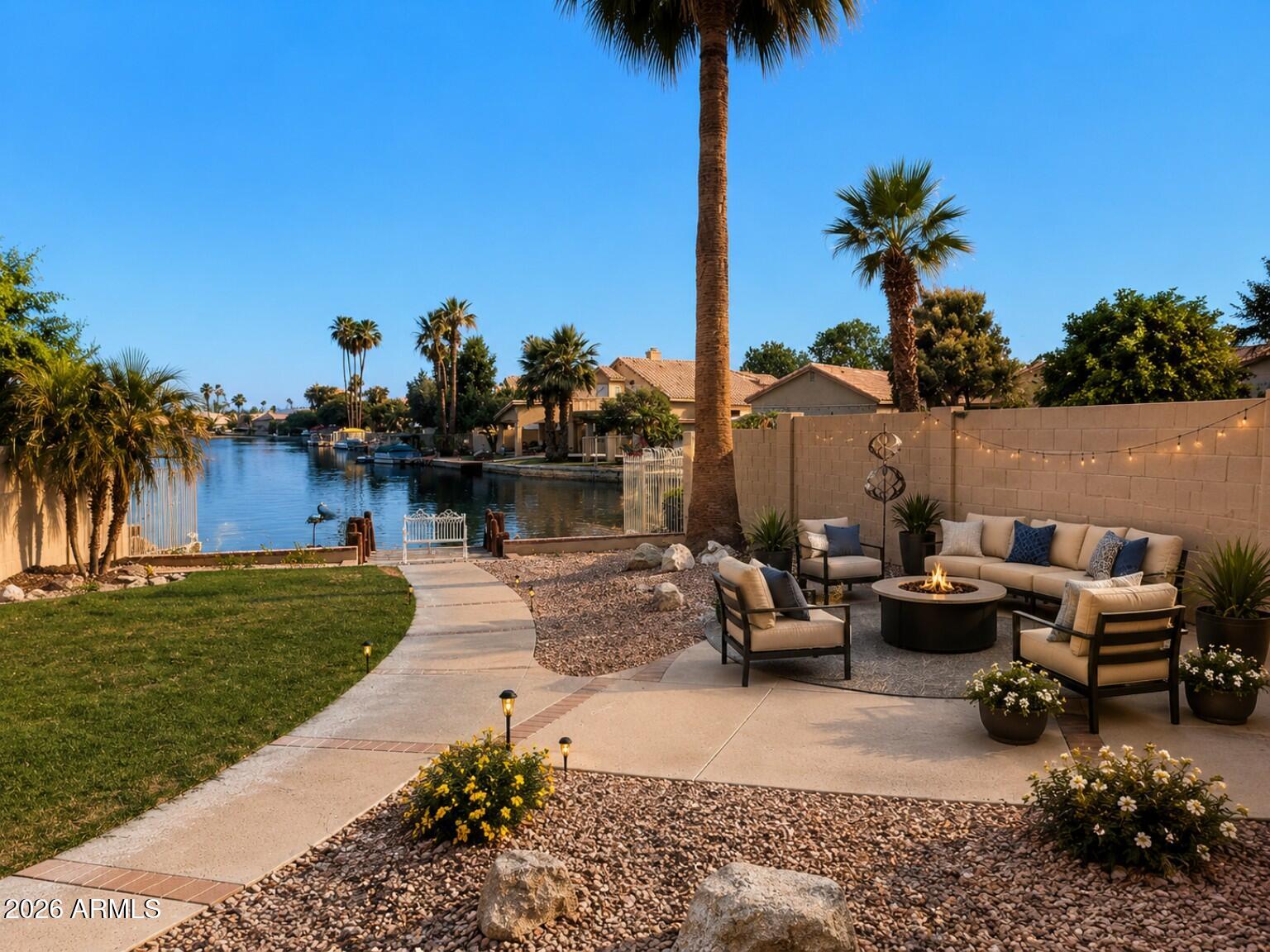 Waterfront Living, Flexible Living, Exceptional Lifestyle! Rare opportunity to own a beautifully updated lakefront home on oversized 10,498 SF waterfront lot in the highly sought-after Manors at Garden Lakes. Enjoy a private dock, expansive outdoor entertaining areas, stunning lake views, fresh interior & exterior paint, brand-new stainless-steel appliances, and a newly installed water softener. The spacious primary suite features a private walk-out balcony overlooking the lake and backyard. Flexible downstairs suite and full bath offer ideal space for guests, multi-generational living, home office, fitness, hobby, or media room use. Private courtyard entry, community pool, spa, bathhouse, BBQ area, front landscape maintenance, boating, fishing, kayaking, & true lock-and-leave convenience! "Welcome to One of the West Valley's Best Kept Secrets"

Nestled within the highly desirable Manors at Garden Lakes, this waterfront residence combines architectural character, flexible living spaces, and an exceptional Arizona lake lifestyle rarely available in today's market.

Situated on an oversized 10,498 square foot waterfront homesite, the property offers an ideal balance of privacy, recreation, convenience, and community amenities.

Recent Improvements
" Fresh interior paint throughout
" Fresh exterior paint with updated two-tone color palette
" Entire perimeter block wall freshly painted
" Brand-new 5 Start Frigidaire Gallery stainless steel kitchen  
   appliance package including:
   *36" French Door Refrigerator w/wine caddy
    Frigidaire Gallery® 30" Smudge-Proof® Stainless Steel    
   *Freestanding Electric Range
   *Frigidaire Gallery® 1.9 Cu. Ft. Smudge-Proof® Stainless Steel   
     Over The Range Microwave
   *Frigidaire Gallery® 24" Smudge-Proof® Stainless Steel Top  
     Control Built-In Dishwasher
" Newly installed Harmony Series 48,000 Grain Digital Water 
   Softener - June 3, 2026
" Transferable 5 yr manufacturer warranties available upon 
   registration and within 60 days of Seller's purchase
" Refreshed and painted private dock with direct lake access
" Professional cleaning completed
" Professional photography, drone imagery, video marketing, and select virtual staging provided to illustrate room functionality and furniture placement possibilities.

Architectural Character & Flexible Living
Unlike many newer homes that can feel repetitive, this residence offers distinctive architectural details and a floorplan designed for a variety of lifestyles. The private front courtyard creates a welcoming outdoor retreat before you even step inside. Wood-trimmed windows, warm wood cabinetry, and thoughtfully designed living spaces provide character and charm throughout the home.

One of the home's most valuable features is the flexible downstairs suite located adjacent to a full bathroom. This versatile space can function as:
" Guest suite
" Multi-generational living area
" Home office
" Fitness room
" Hobby or craft room
" Media room
" Playroom
" Additional living space
The flexibility allows buyers to customize the home around their lifestyle both now and in the future.

Primary Suite Retreat
The spacious upstairs primary suite serves as a private sanctuary overlooking the waterfront setting. Features include:
" Private walk-out balcony
" Elevated lake views
" Backyard and dock views
" Peaceful sunrise and sunset viewing opportunities
Imagine beginning your mornings with coffee overlooking the water and ending your evenings with Arizona's famous sunsets reflected across the lake.

Waterfront Lifestyle
This home was designed to maximize its connection to the lake.
The kitchen, family room, living room, and primary suite all benefit from beautiful water views.
Outdoor features include:
" Private dock
" Covered patio
" Multiple entertaining areas
" Oversized waterfront yard
" Fishing, boating, kayaking, paddle sports, and waterfront recreation directly from your backyard
The property offers room to entertain on both a large and intimate scale.

Community Amenities
The Manors at Garden Lakes offers a true lock-and-leave lifestyle with amenities rarely found in the West Valley.

Amenities include:
" Private community pool
" Heated spa
" Bathhouse
" Outdoor shower
" Lakeside BBQ and picnic area
" Front landscape maintenance included through the HOA
" Approximately 105 homes within this exclusive enclave
The home's location provides convenient access to these amenities while maintaining the privacy of your own waterfront retreat.

Whether searching for:
" Primary residence
" Winter retreat
" Seasonal residence
" Vacation Rental
" Executive relocation
" Multi-generational living
" Vacation-oriented lifestyle home
" Waterfront entertainer's dream

This property offers an increasingly rare opportunity to enjoy Arizona waterfront living on an oversized lot with flexible living spaces, architectural character, private dock access, and resort-style community amenities. The P-83 Entertainment District is just minutes away!! 

"Few homes combine an oversized waterfront homesite, private dock, flexible floorplan, balcony lake views, private courtyard entry, and lock-and-leave convenience into one complete package."
