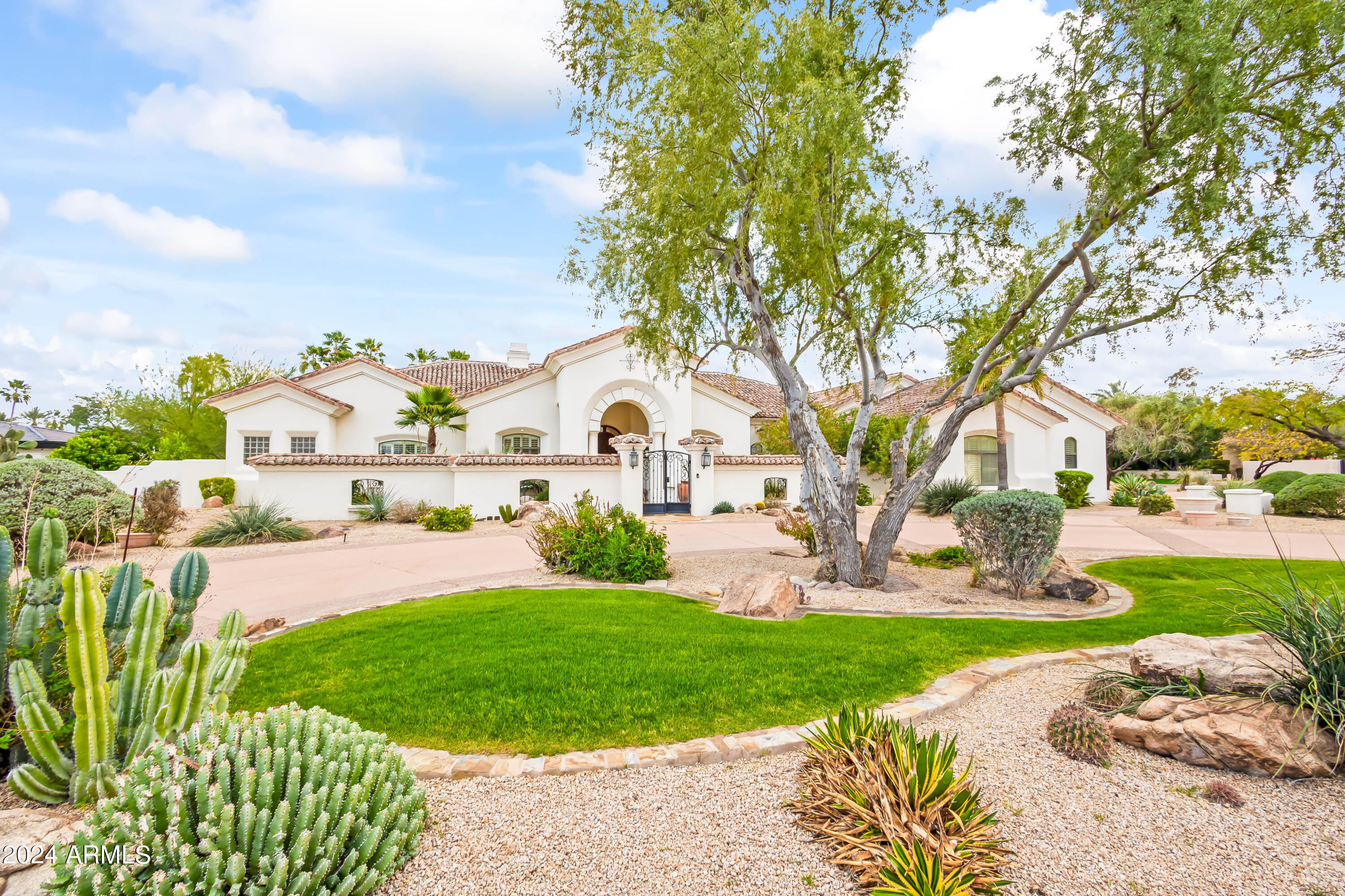 Tucked in the heart of Paradise Valley and in one of the most desirable neighborhoods sits this 4-bed, 4.5 bath estate. This Santa Barbara home sits on over an acre lot; enter through the private courtyard into high ceilings, arched entry and doorways, and tons of natural light. Open concept great room, living room with gas fireplace, formal dining, and chef's kitchen with high end appliances, multiple ovens, island, additional eat-in kitchen counter, and breakfast room. Primary suite includes private entry into backyard, fireplace, dual vanities, closets, private toilets, and oversized shower with separate bathtub. Enjoy the best of Arizona's indoor/outdoor living, exiting the family room's French doors into the backyard. Dine outside with family and friends under the covered patio that