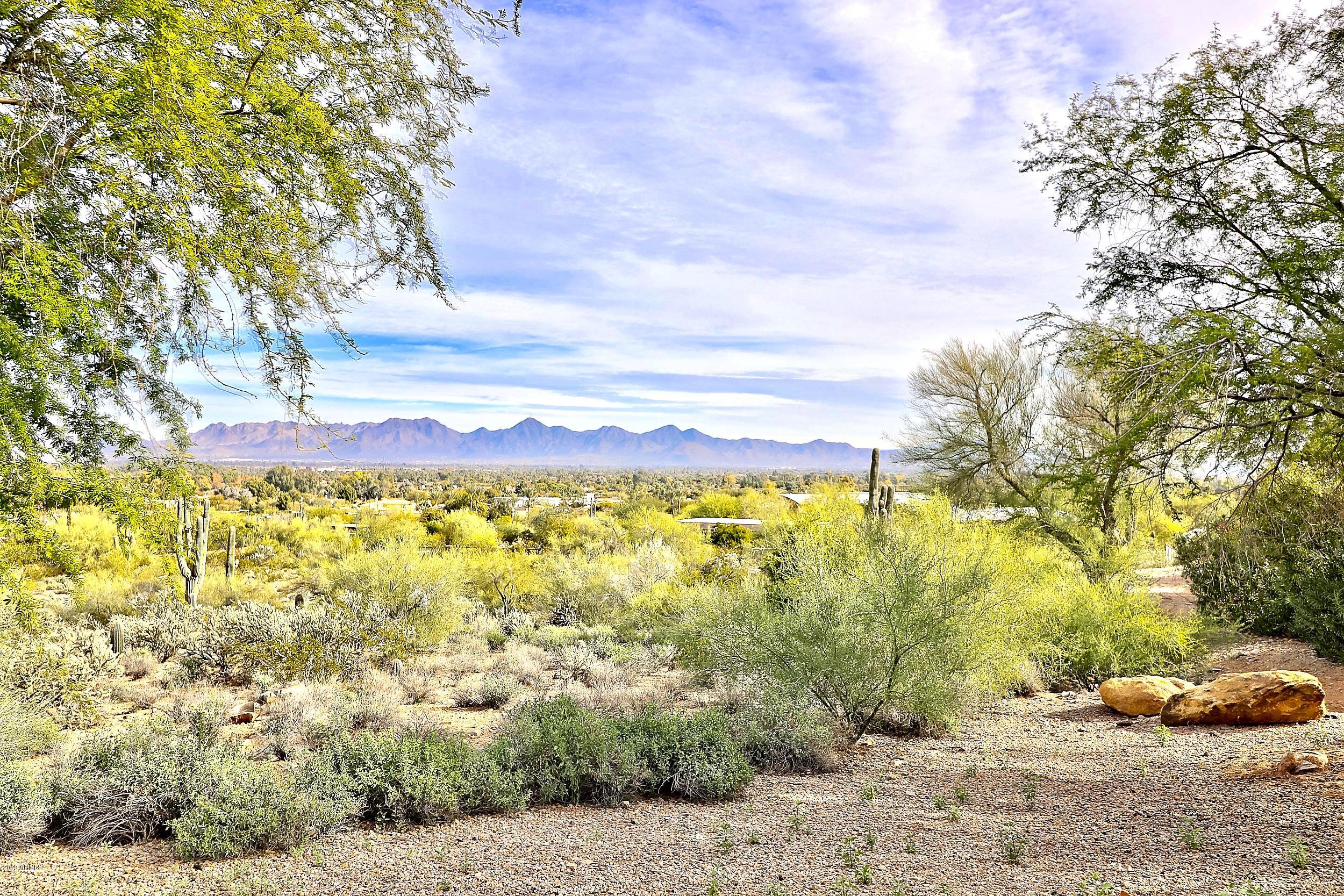 Most spectacular panoramic city lights and mountain views from this gentle sloped 5+ acres in Mummy Mountain Estates. Gated meandering driveway pass the 2 bedroom guest house/ caretakers cottage,  continue on to the main home at the top. Rare single level mountainside estate has been partially remodeled. New kitchen and updated electrical. Ready for your personal selection of flooring and baths. High ceilings, great room w/ fireplace and wall of windows. 2/2 bedroom split, formal dining, large wine room, large bonus room off garage, 6' hallways. Unlimited possibilities for addition/ remodel or scrape and build your ultimate dream home. One of the nicest 5 acre estates on the market today at an incredible price! Additional 5 adjacent acres available for a 10 acre grand estate.