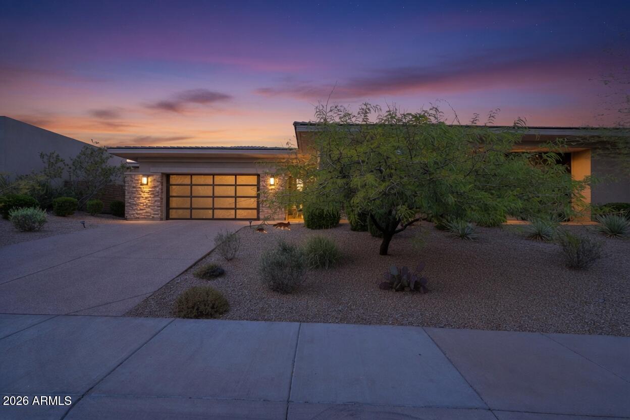 Welcome to this stunning Toll Brothers contemporary in the gated enclave of Adero Canyon. This step-free, single-level home offers 4 bedrooms, 4.5 bathrooms, plus a generous-sized detached guest casita with 2 rooms and a full bath. Enter through the private courtyard, through stunning steel-framed glass double doors, and into a foyer that opens to a breathtaking great room. Soaring wood-beam ceilings, herringbone wood floors, and walls of 2 separate sliding glass doors frame the desert hillside beyond, flooding the space with natural light. The chef's kitchen is designed to impress -- quartz island with bar seating, gas range, walk-in pantry, and built-in refrigerator. Whether hosting holiday dinners or enjoying a quiet morning coffee, this space is the heart of the home. Two fireplaces warm the living spaces, including a stunning floor-to-ceiling stone surround. Two primary suites each wake up to mountain views, while the spa-like primary bath invites you to unwind with a soaking tub, walk-in shower, double vanity with LED mirrors, and warm stacked stone accents. Outside, your private pool awaits beneath the desert sky, with a covered patio perfect for sunset evenings -- and no grass to maintain. (Select photos show virtual grass for inspiration.) This is desert modern living at its finest. Welcome home.