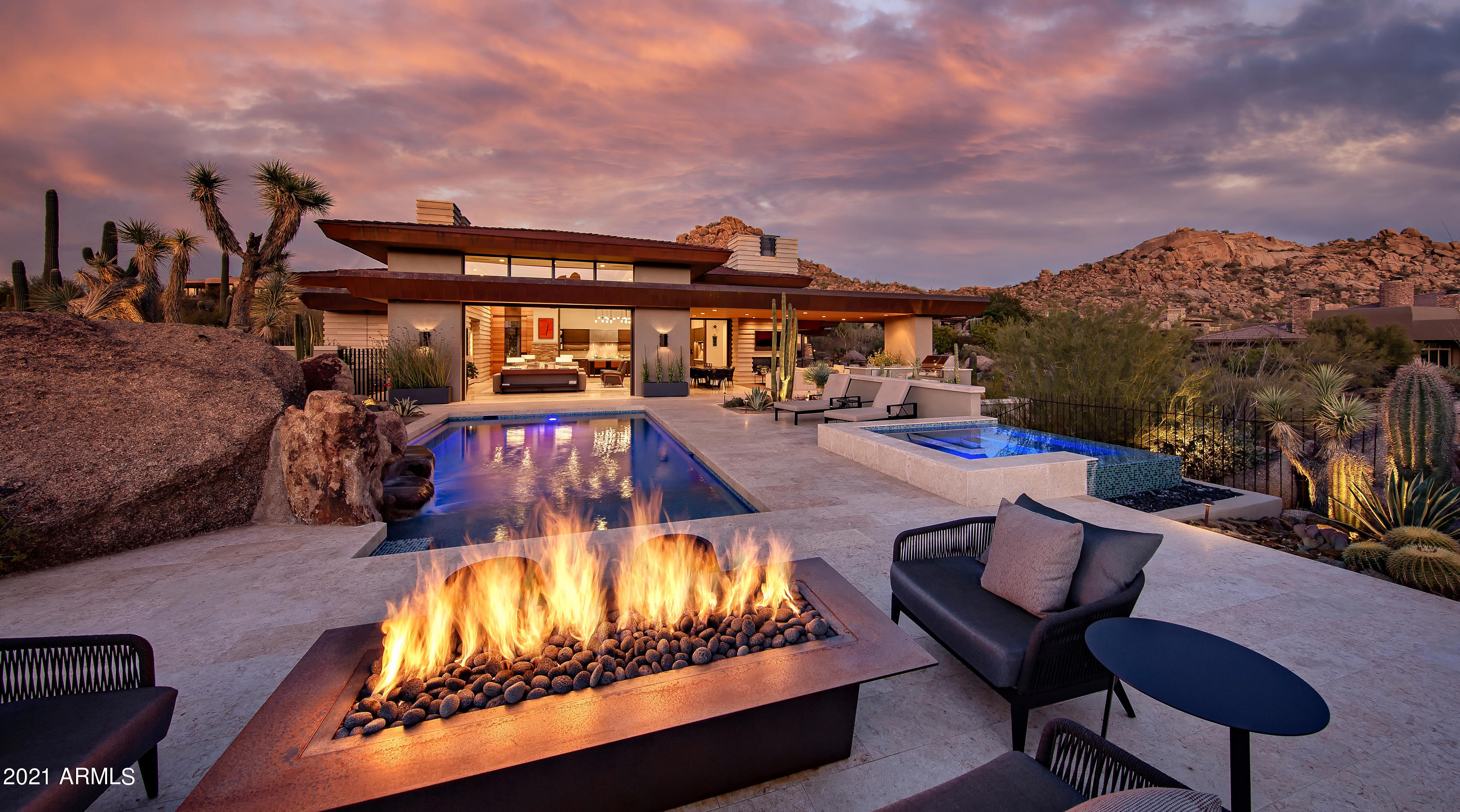 Desert Prairie-design with framed Pinnacle Peaks views in the community of Estancia * Award-winning design by CP Drewett includes timeless materials & a seamless indoor/outdoor floorpan * Architectural materials include undulating limestone, Madre Perla quartzite, hemlock inset ceiling details, a forged steel fireplace & Copper roofing fascia * The great room floor plan flows seamlessly to the outdoor living areas with integrated limestone flooring that carries through multiple, motorized pocket doors * Zero interior steps * Main house includes an open great room to kitchen, oversized master suite, 2 guest ensuites & a bonus/exercise area * Detached guest house includes a living area and bedroom with full bath * A walk-in wine room & climate controlled 3-car garage complete the residence *